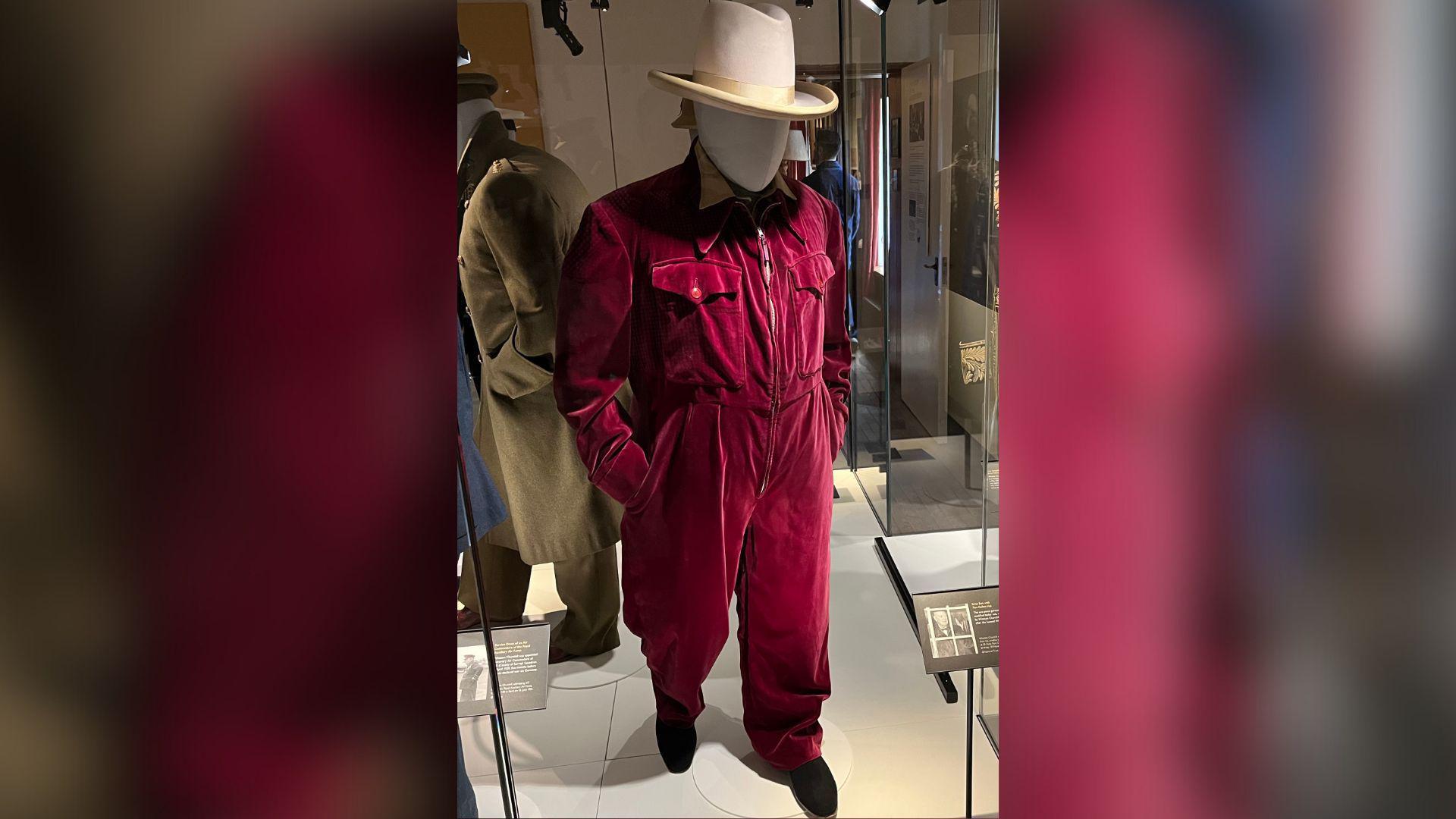 Churchill's red siren suit and ten-gallon hat inside a glass display case.