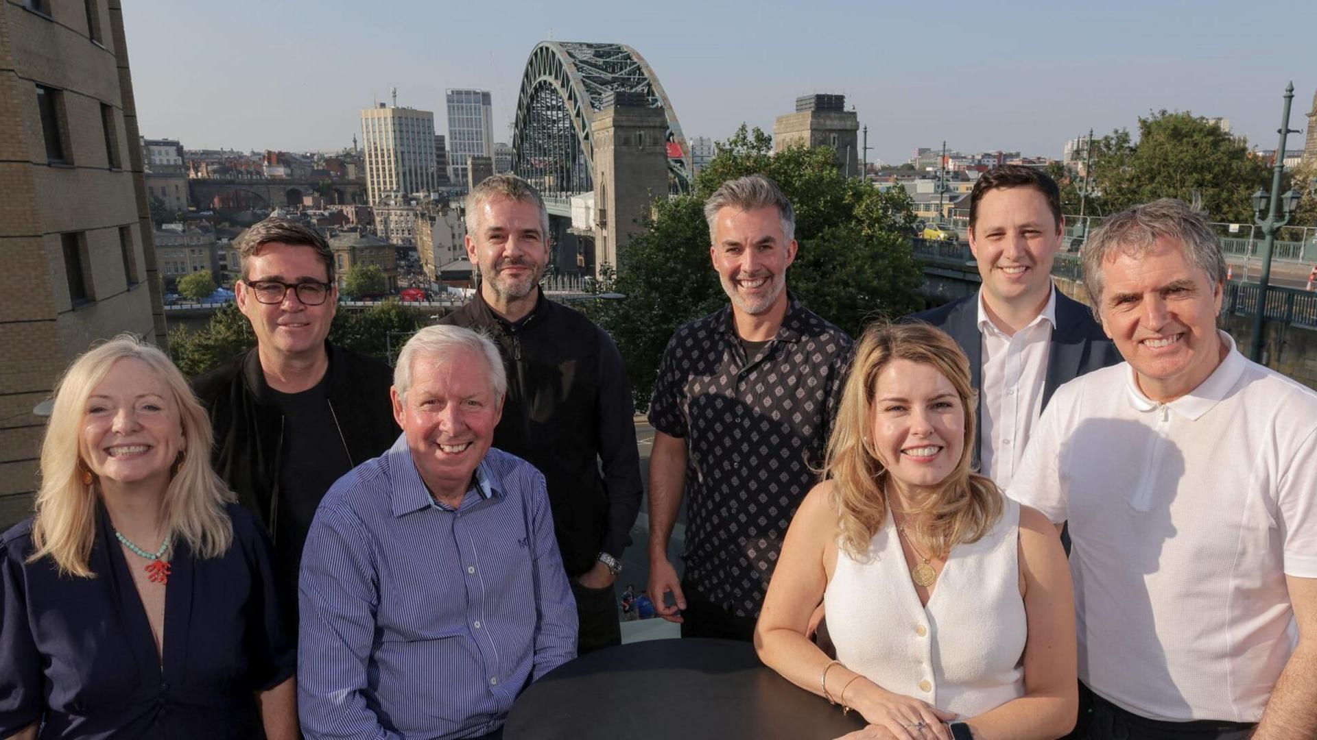 Seven northern mayors are sitting/standing in front of the Tyne Bridge and smiling at the camera. Sir Brendan Foster also joins them. (Right to left) Tracy Brabin, Andy Burnham, Brendan Foster, Oliver Coppard, David Skaith, Kim McGuinness, Ben Houchen and Steve Rotheram.