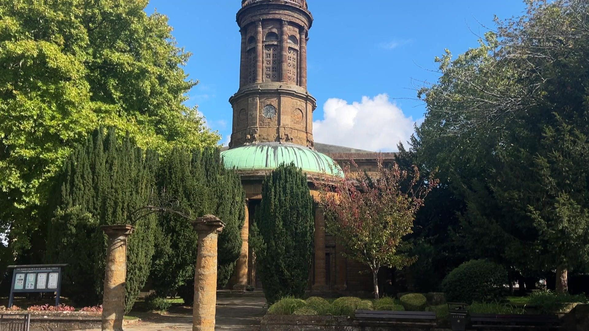 St Mary's Church is a large brown building with green space in front, and around it.