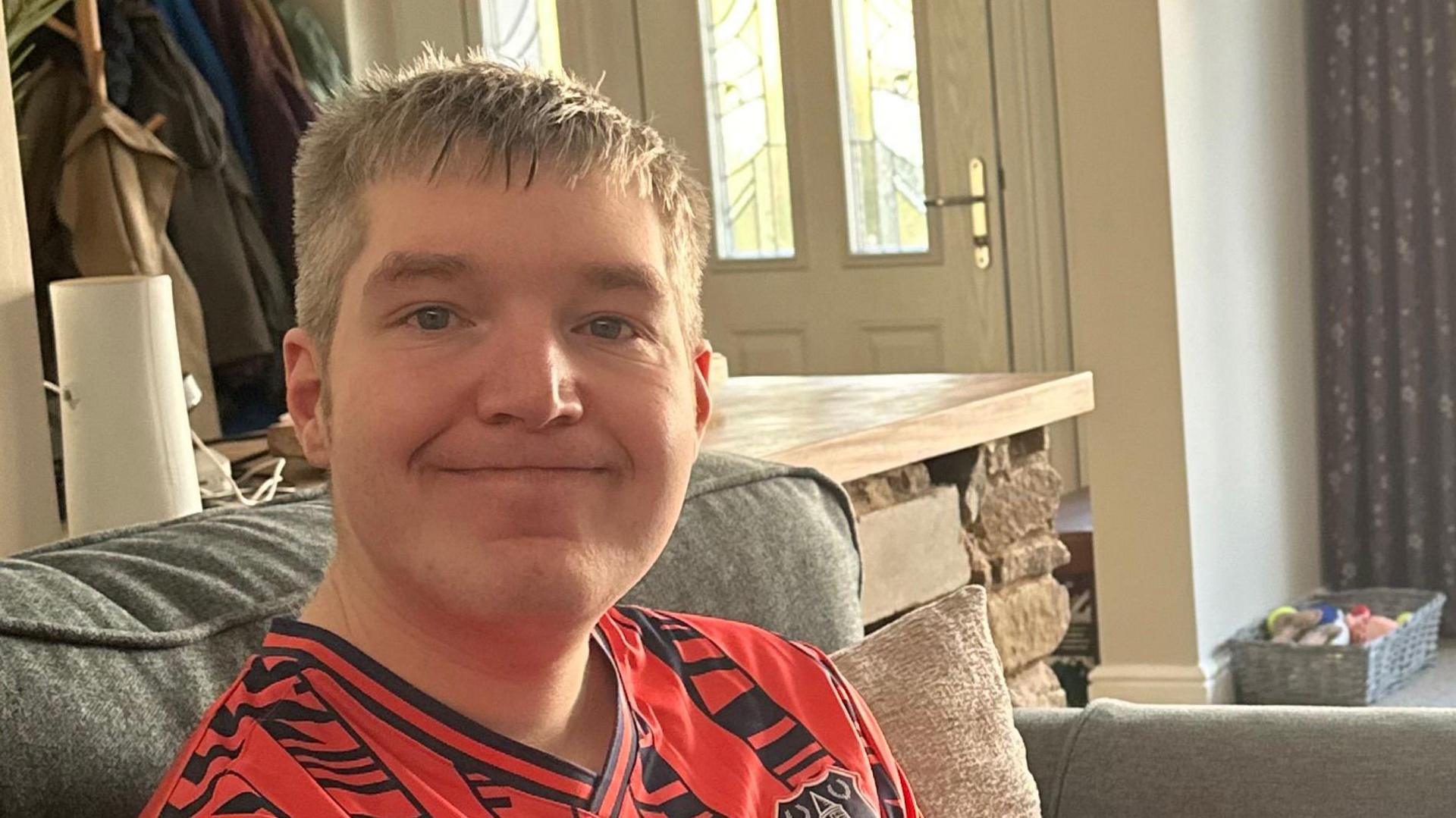 Jack Hickinbotham is pictured smiling, he is wearing an orange sports shirt