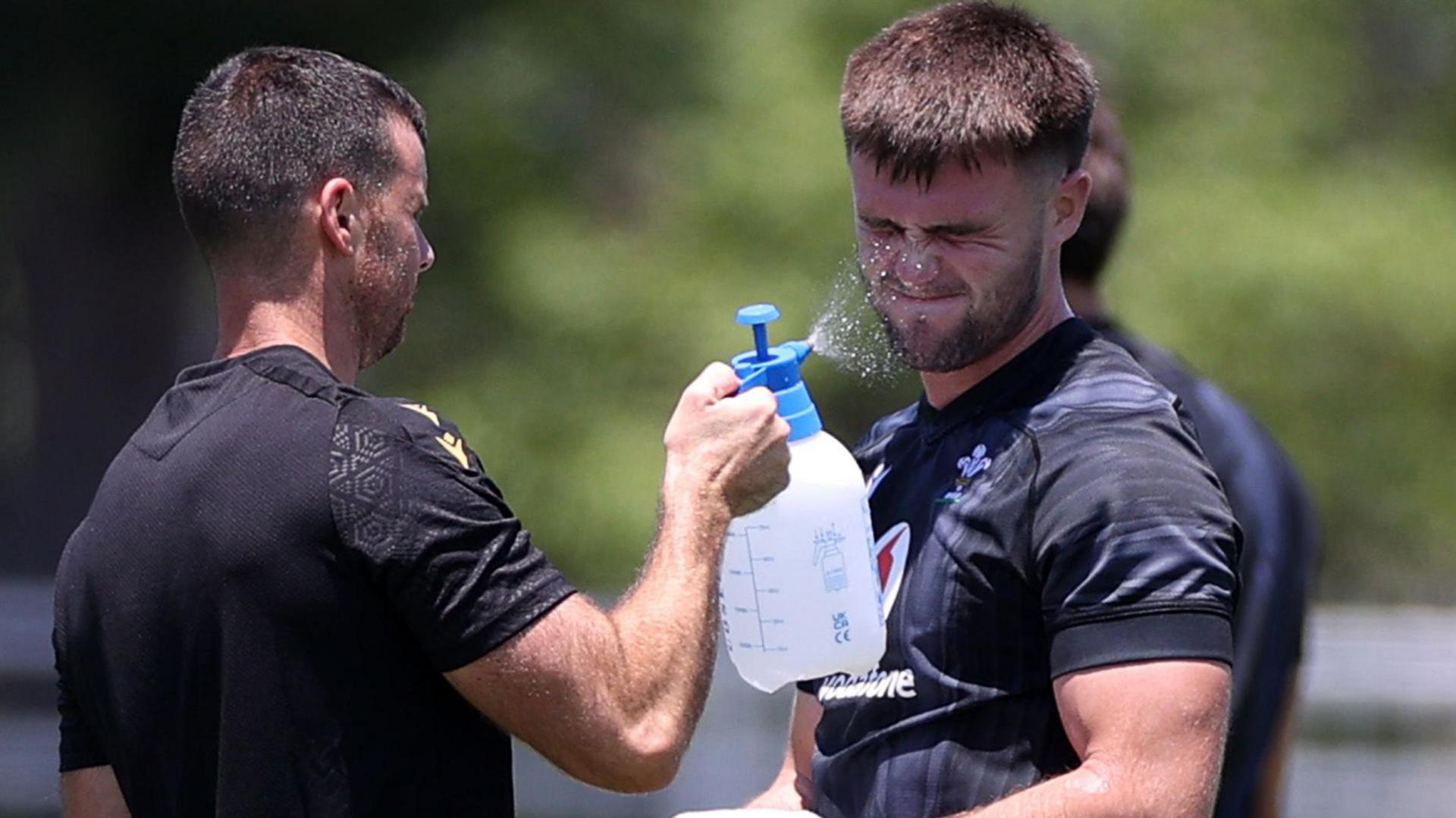 Joe Roberts is sprayed pinch h2o by nutritionist Chris Edwards during training