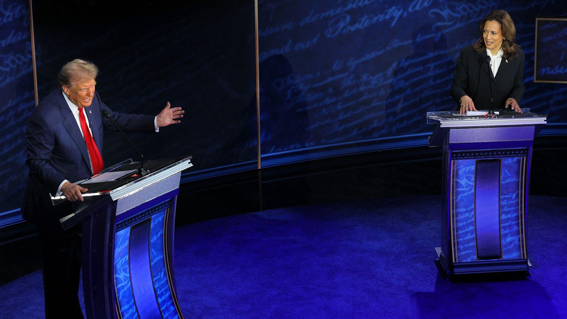 Presidential candidates Donald Trump and Kamala Harris stand behind lecterns in a studio, debating