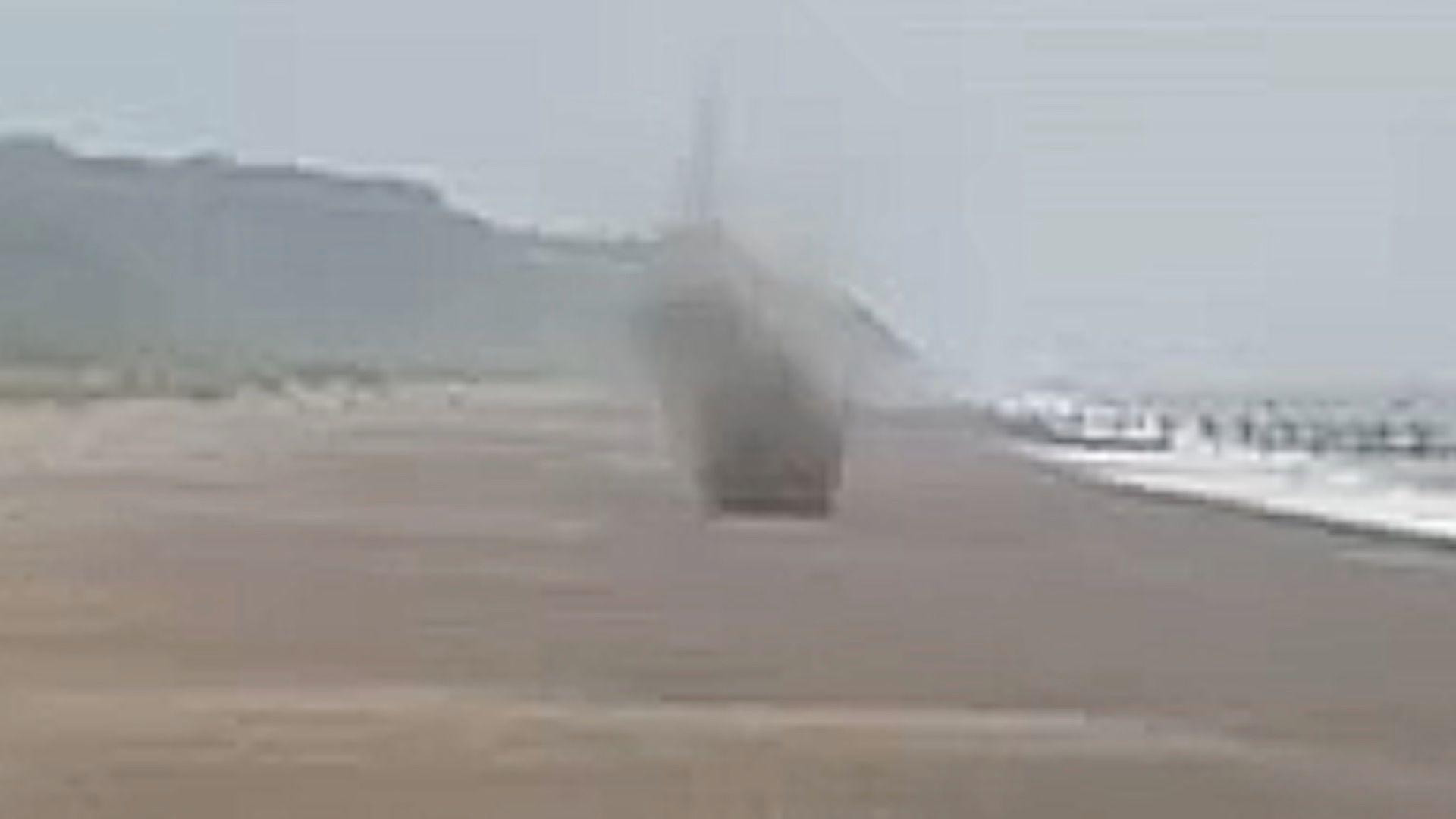 Mortar exploding on a beach.