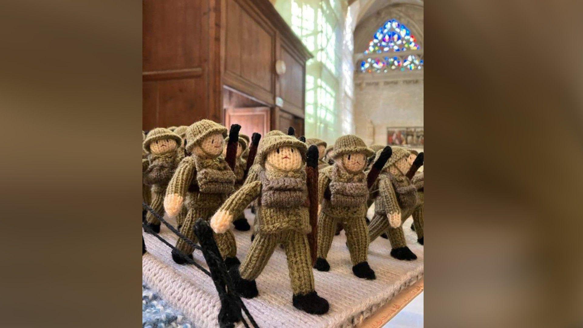 Small knitted soldiers arranged on a table 