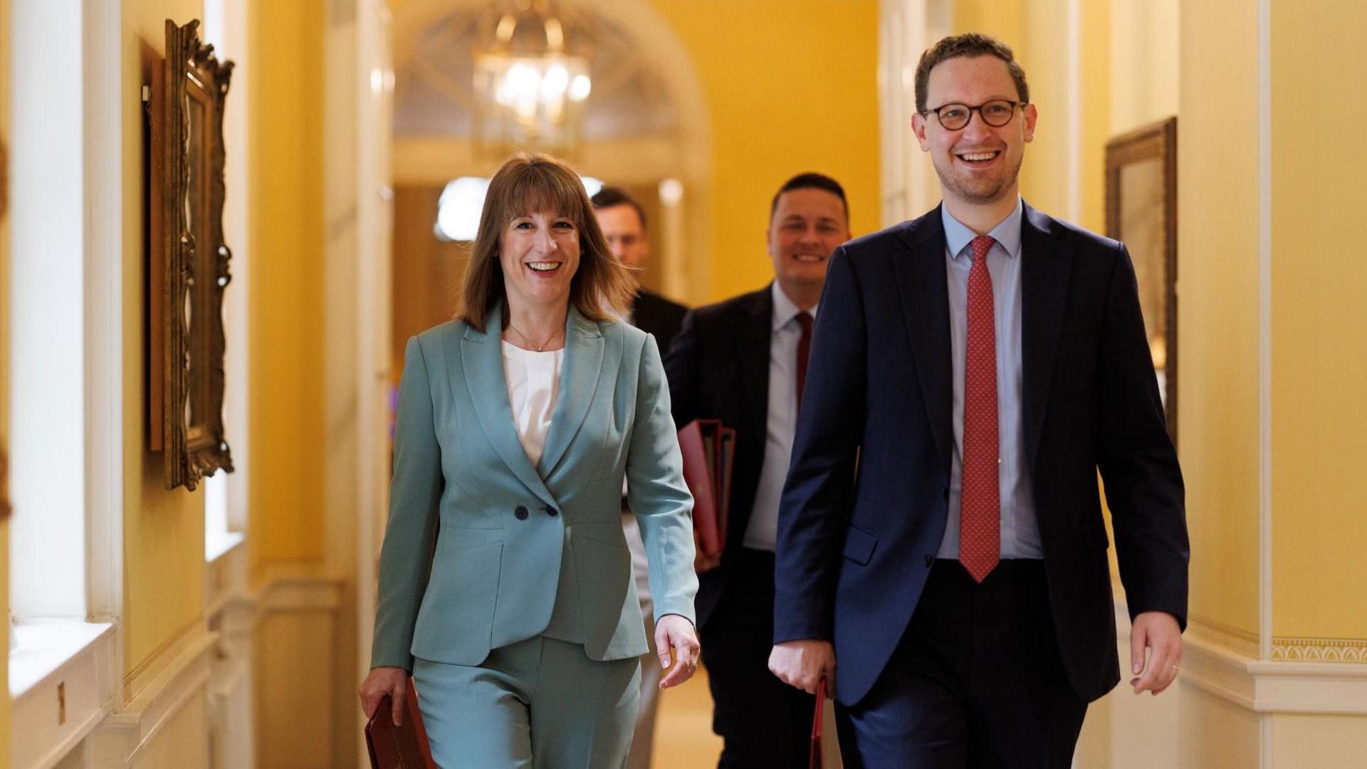 Members of the Cabinet walk through a corridor in 10 Downing Street.