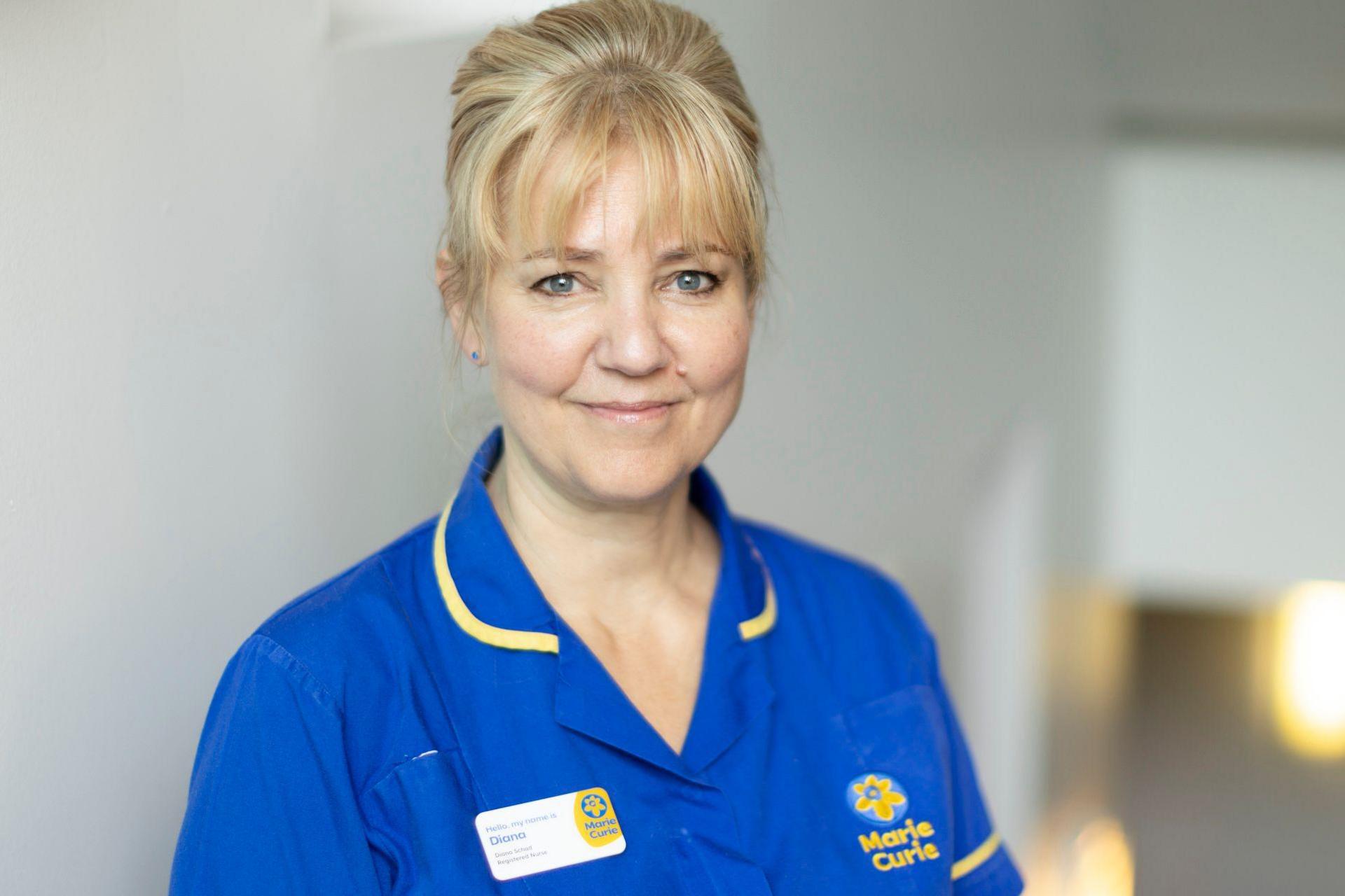 Diana, a middle-aged blonde woman, smiling in her blue Marie-Curie nurses uniform