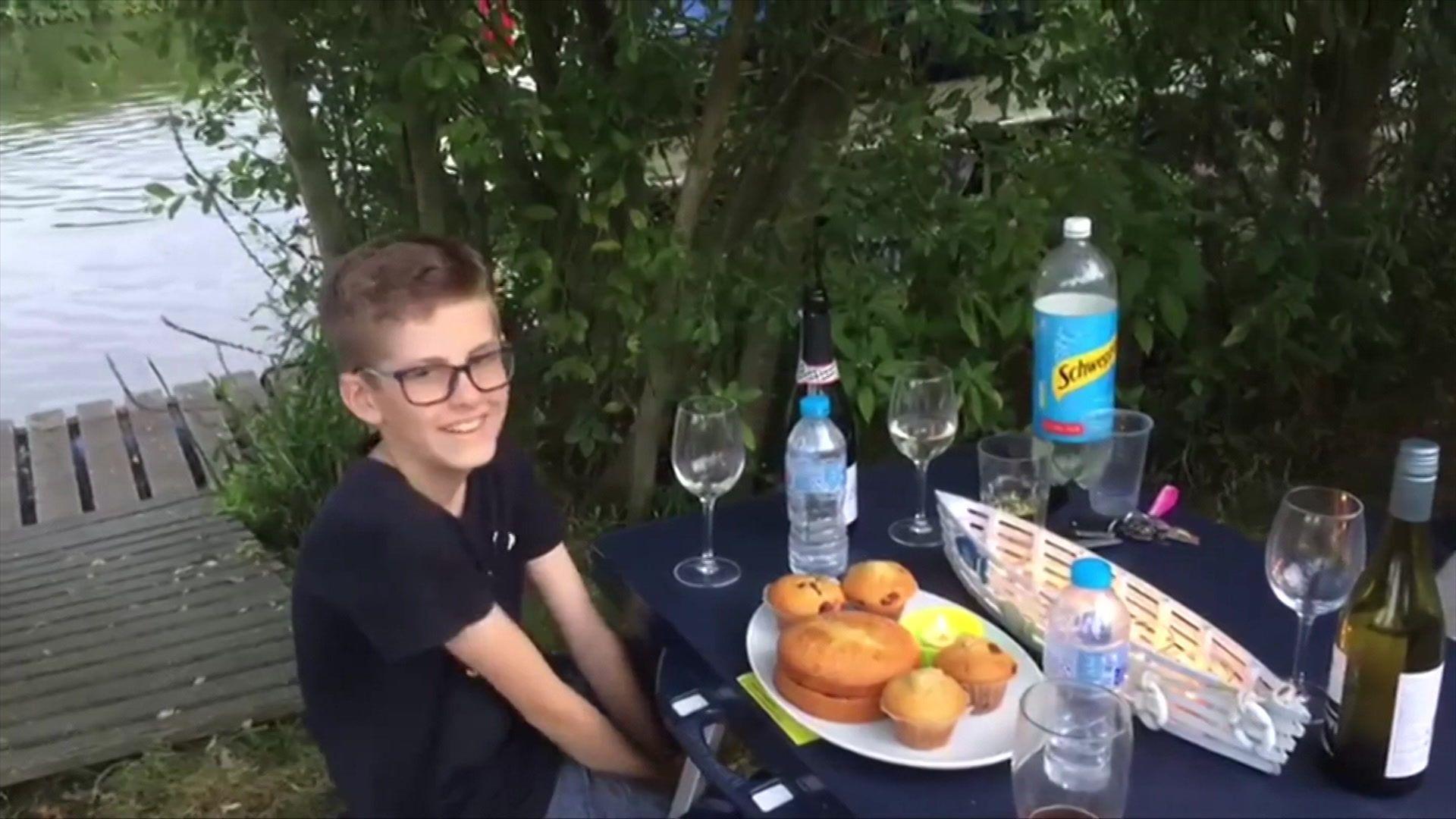 Isaac Kenevan sits at a table with food on it