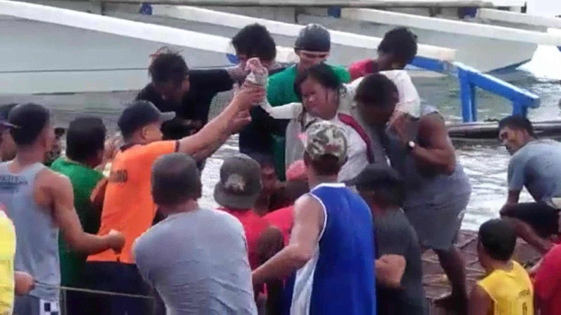 Woman being brought ashore