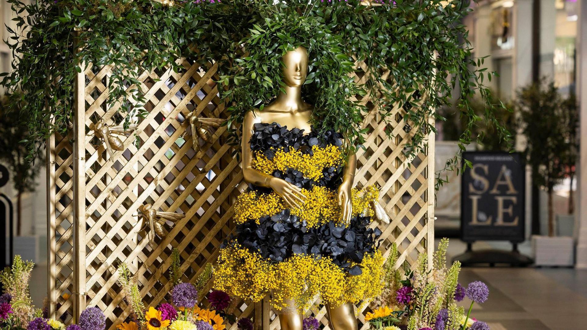 Rowetta sculpture in yellow and black striped dress