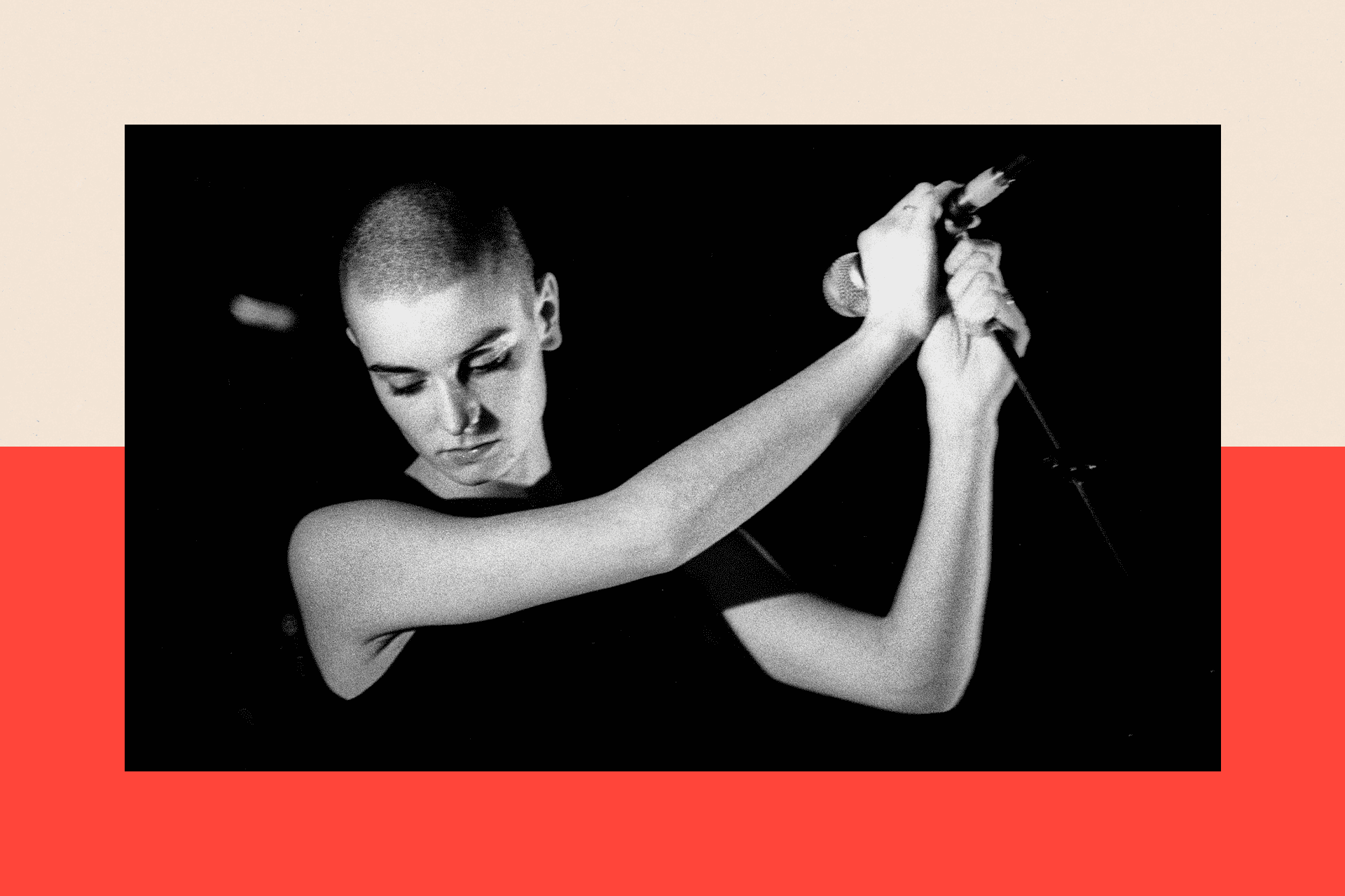 Sinead O'Connor holds a microphone with her head bowed