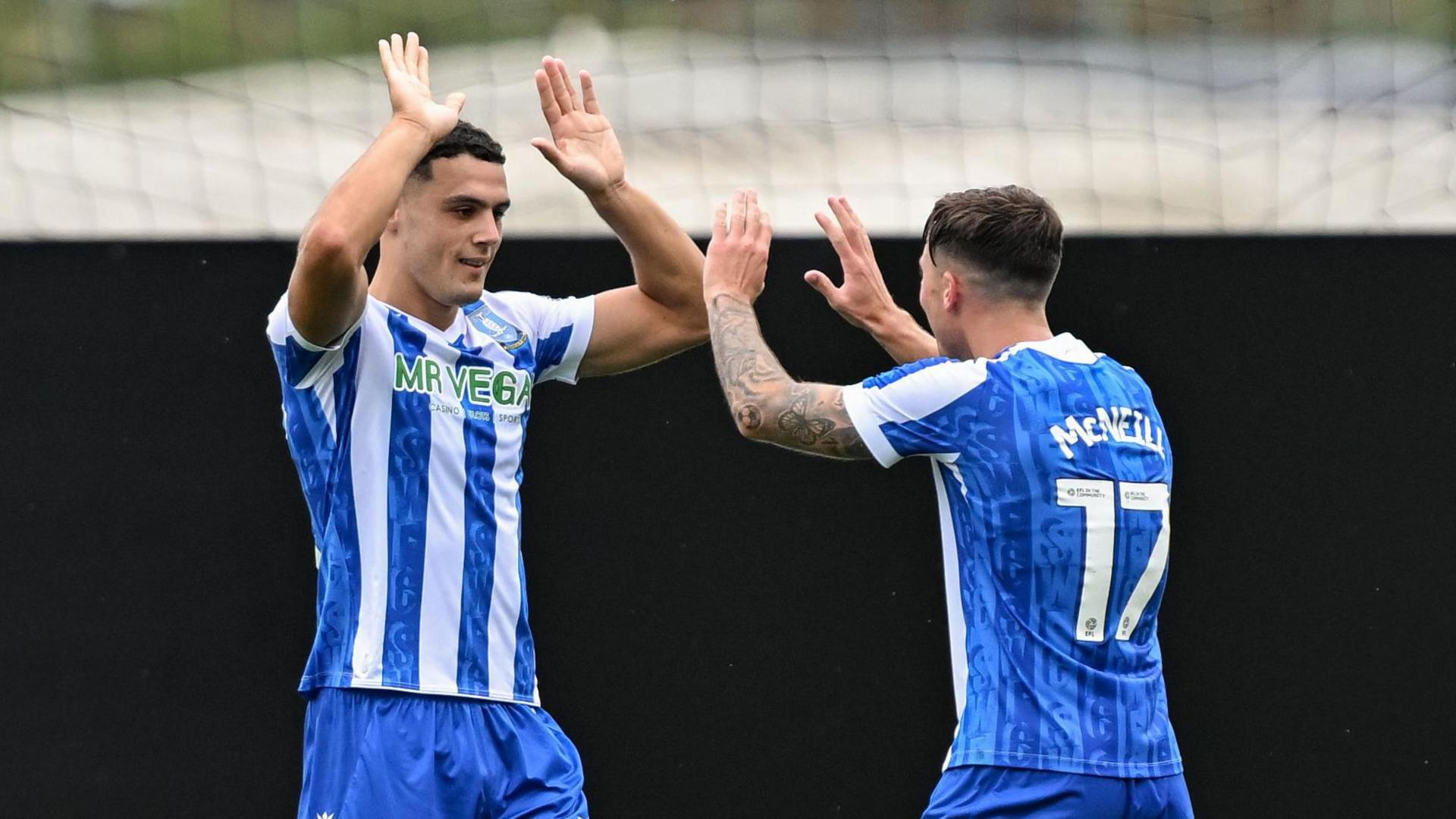 Bailey-Tye Cadamarteri celebrates with Sheffield Wednesday team-mate Charlie McNeill as both men raise their arms