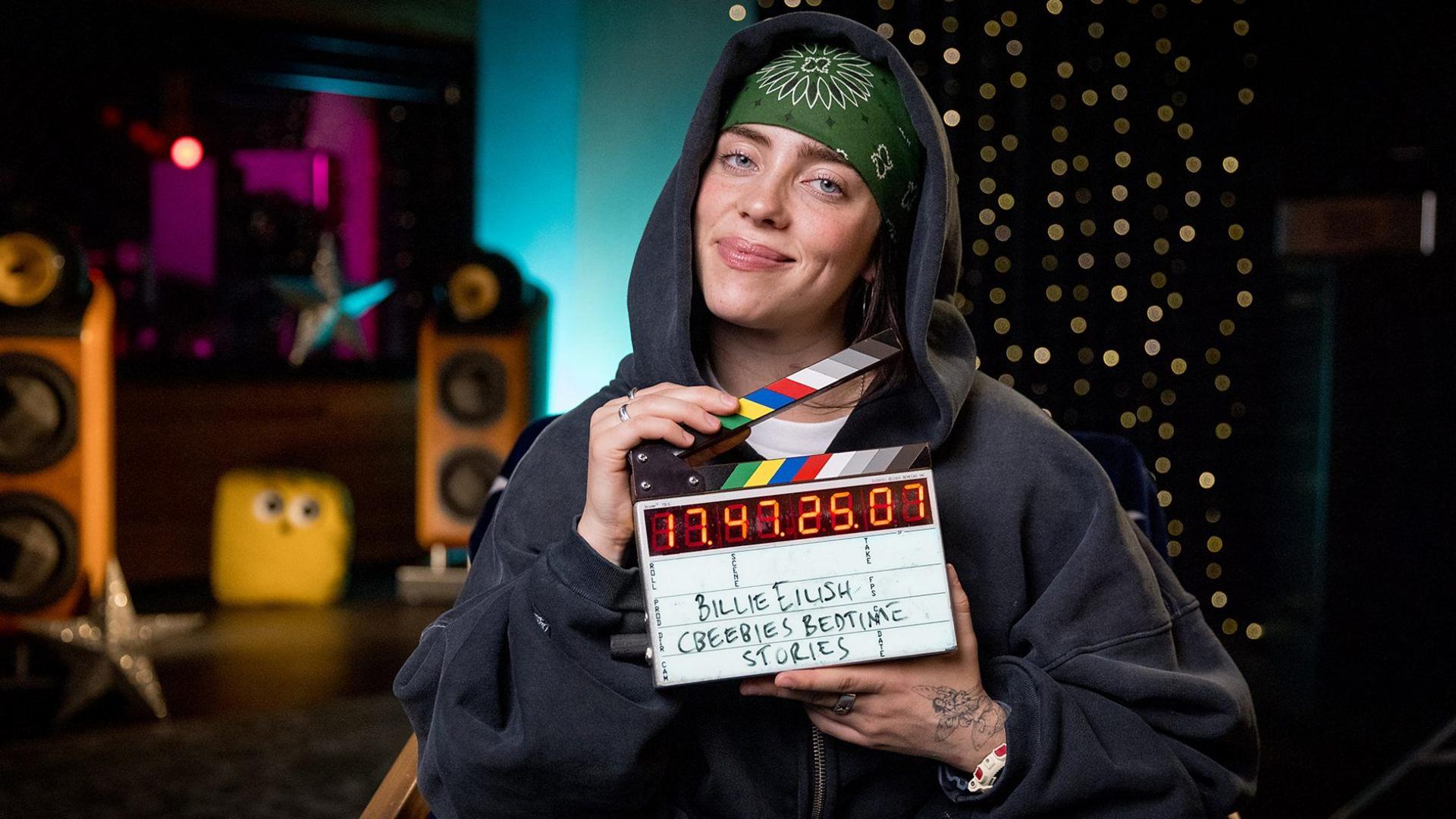 Billie Eilish holding clapperboard for filming