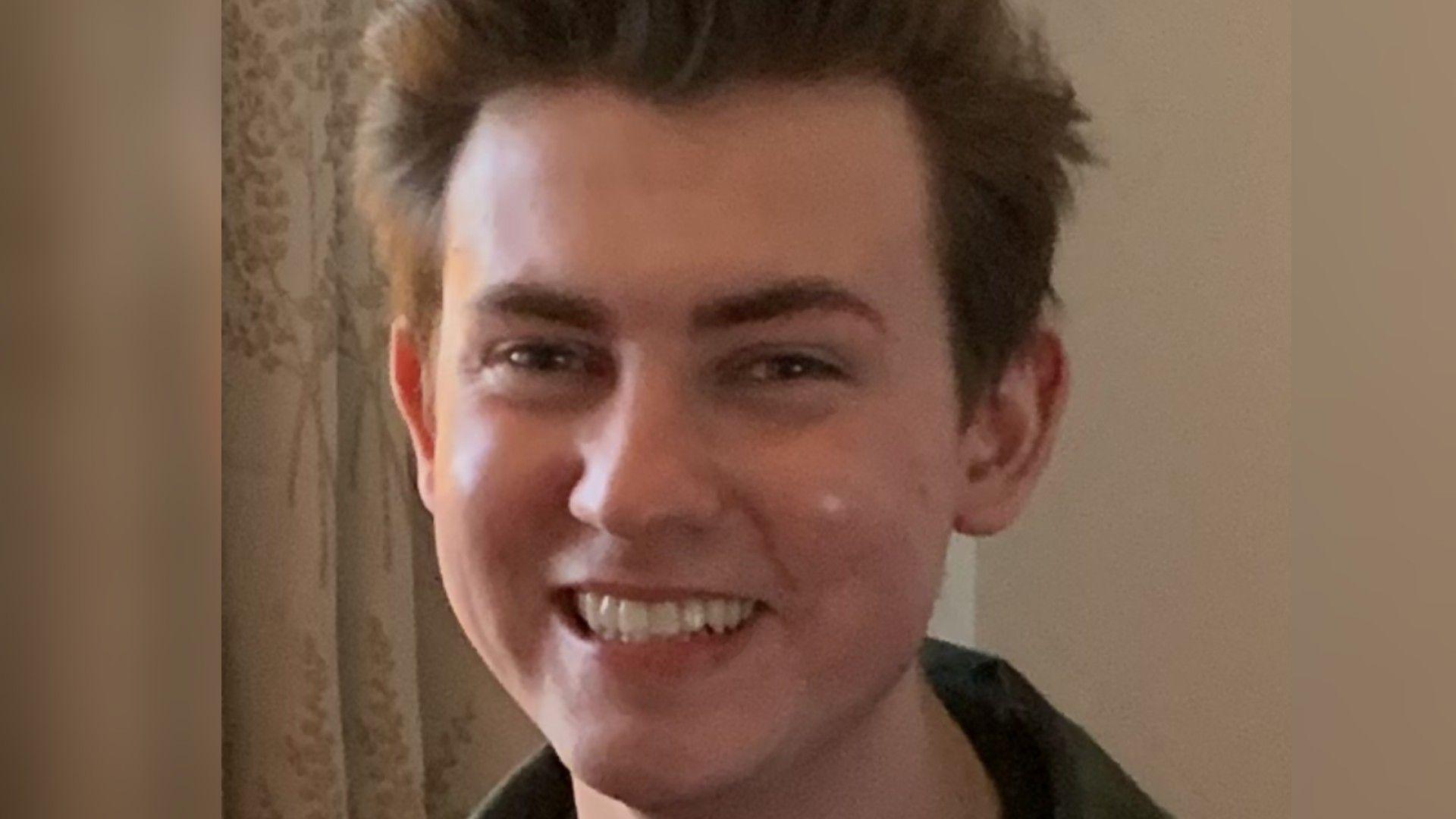 A young man with dark hair smiling.