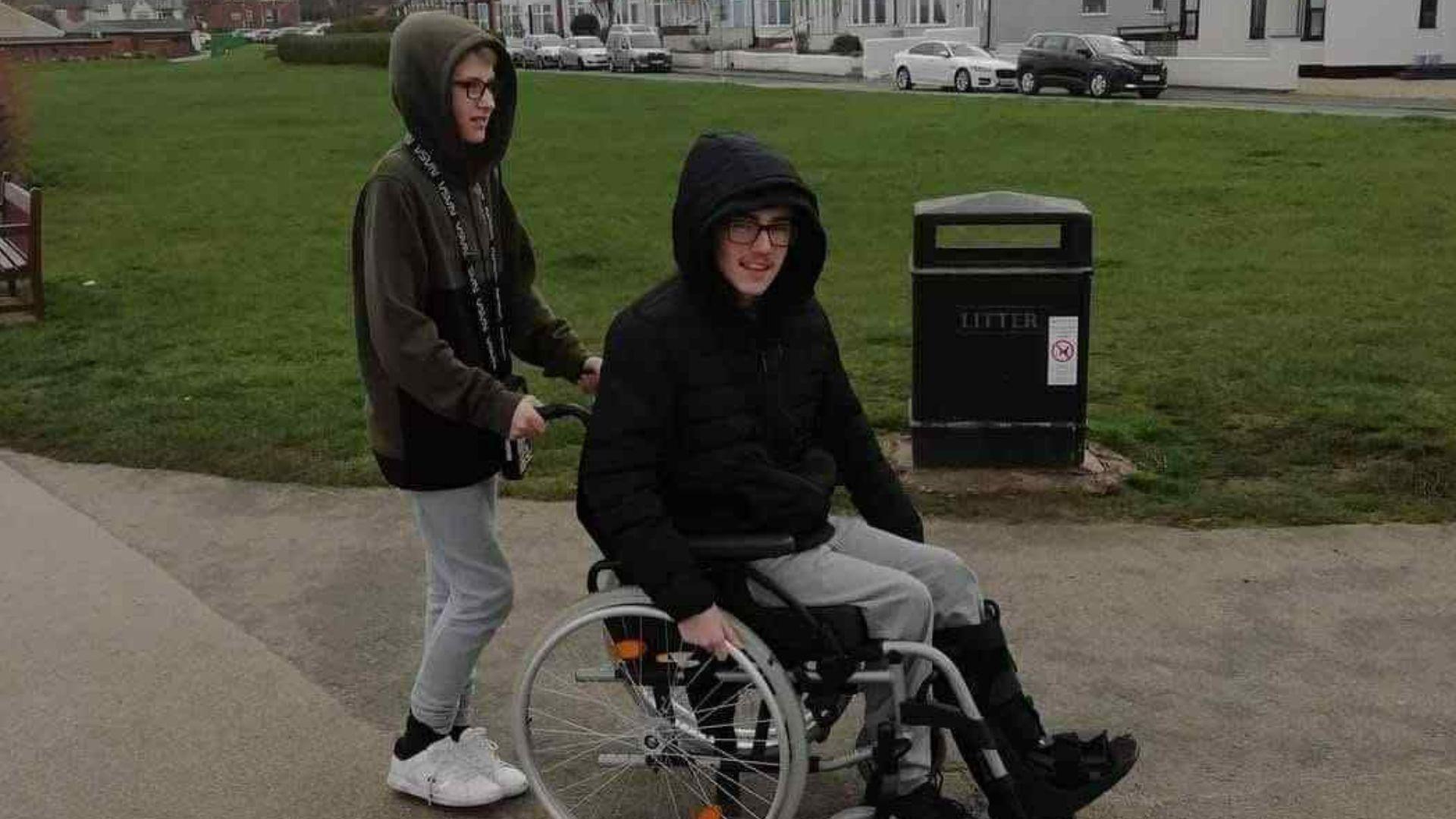Image shows 16-year-old Mylo being pushed in a wheelchair.
