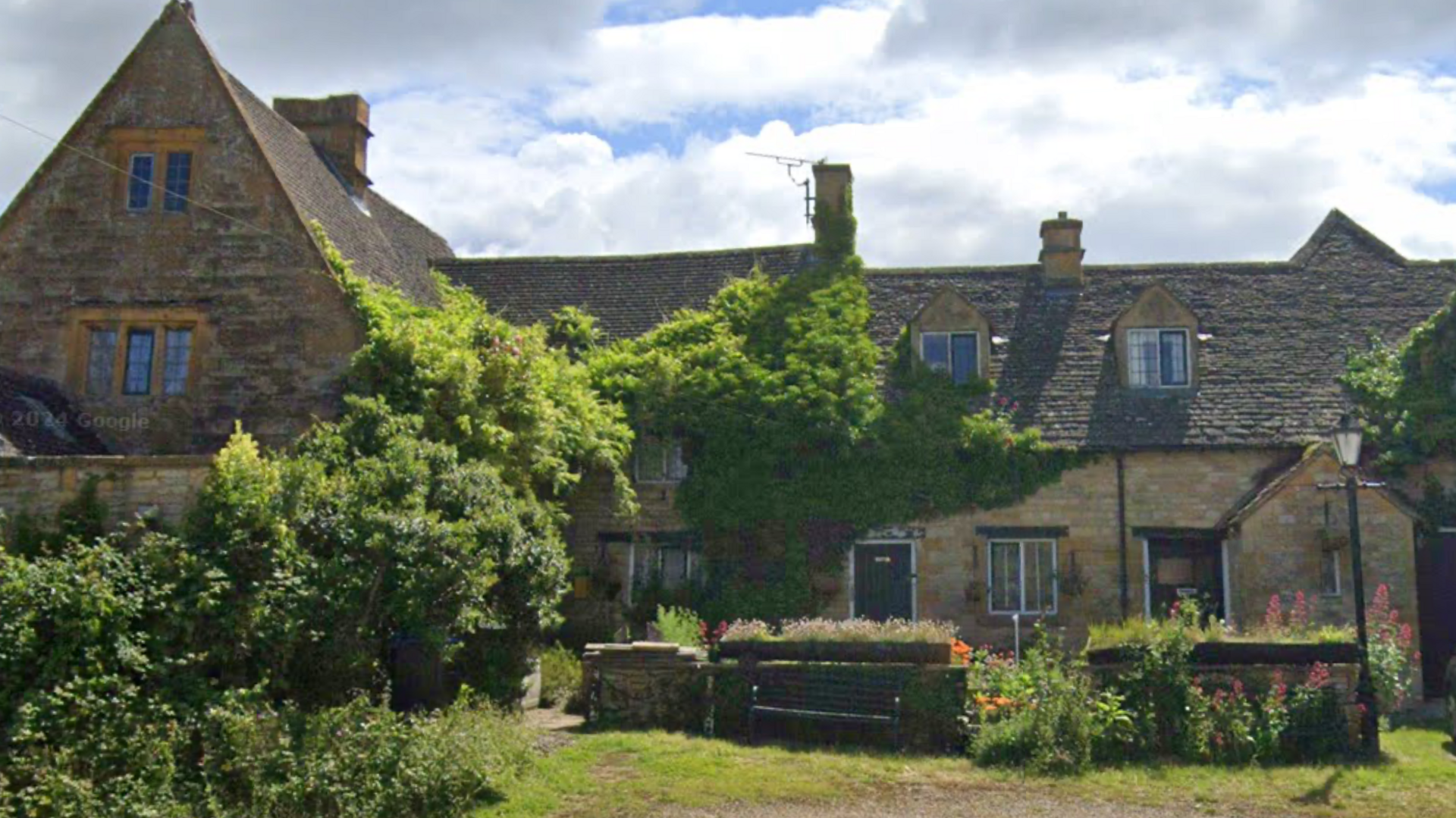 The outside of The Fox and Hounds Inn with greenery growing on the building. 