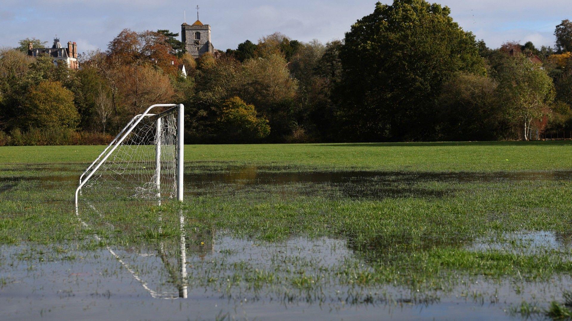 Football pitch with goals sitting in large puddles of standing water