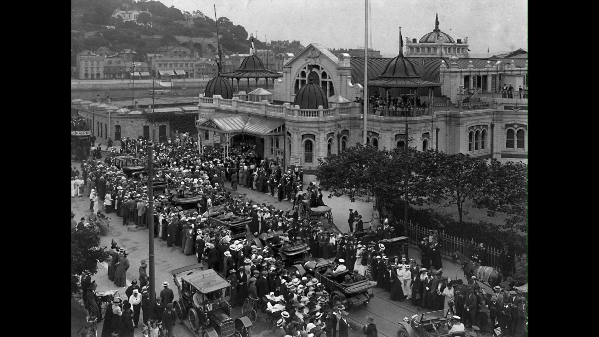 A black and white photo shows cars queuing up to allow the soldiers into the theatre.