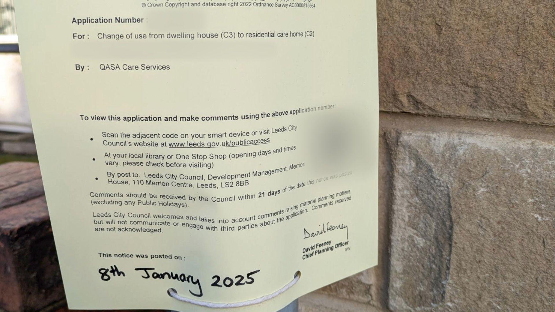 A notice indicating a planning application on a lamp post.