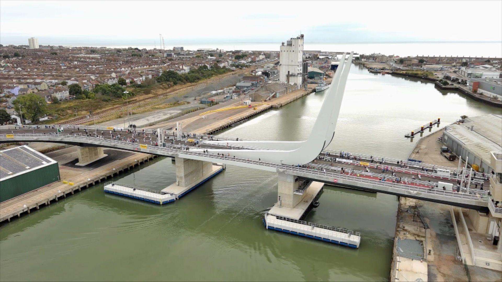 An aerial photo of the Gull Wing bridge, showing people walking over it