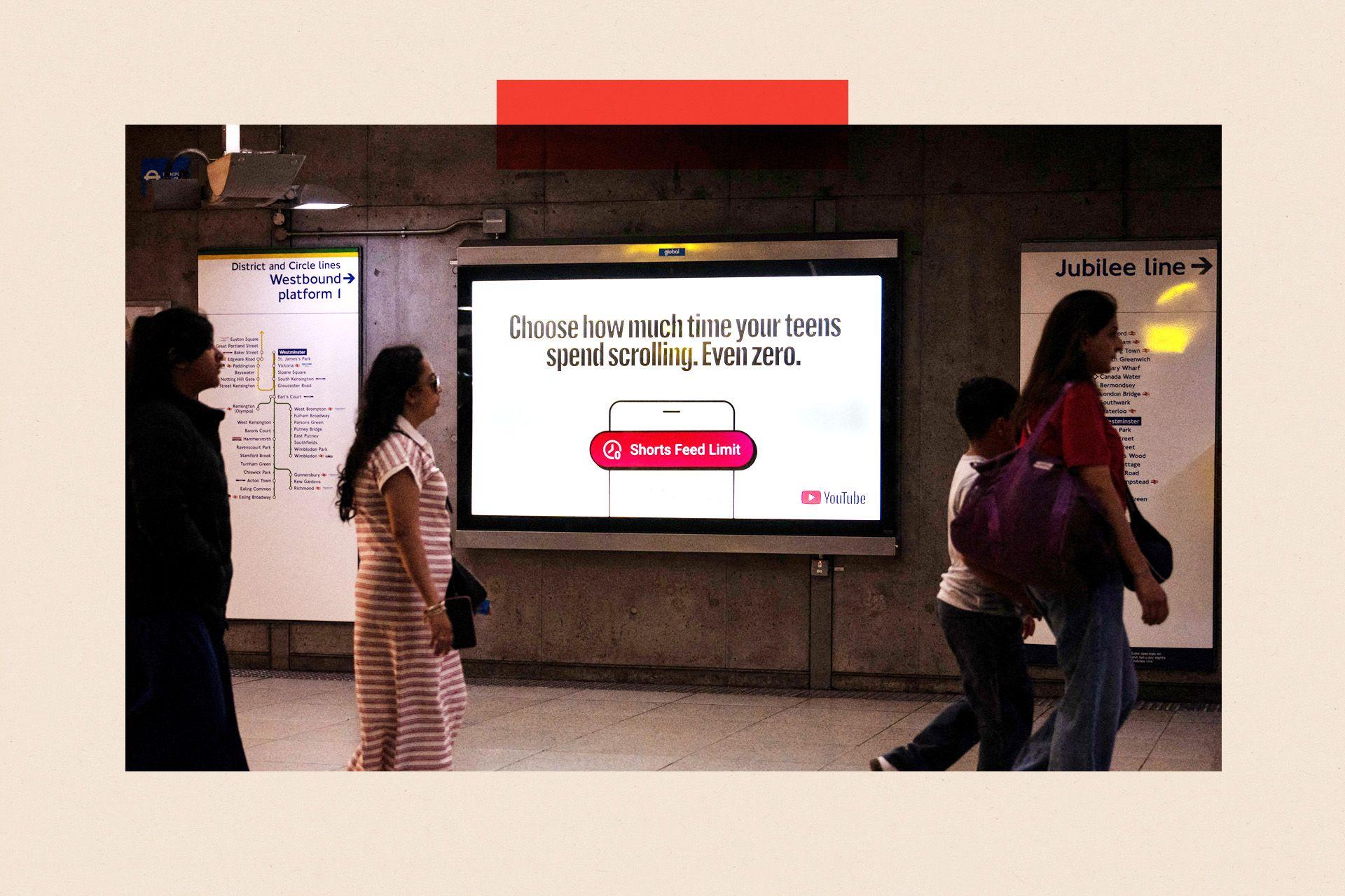 A YouTube advert at Westminster Underground station in London reads: "Choose how much time your teens spend scrolling. Even zero." Below that is the outline of a mobile phone and an image of a red notification that reads: "Shorts feed limit" alongside an icon of a clock. The YouTube logo is also visible on the advert. Strolling past are three women and a boy. Maps of the westbound District and Circle lines and the Jubilee line are also visible.