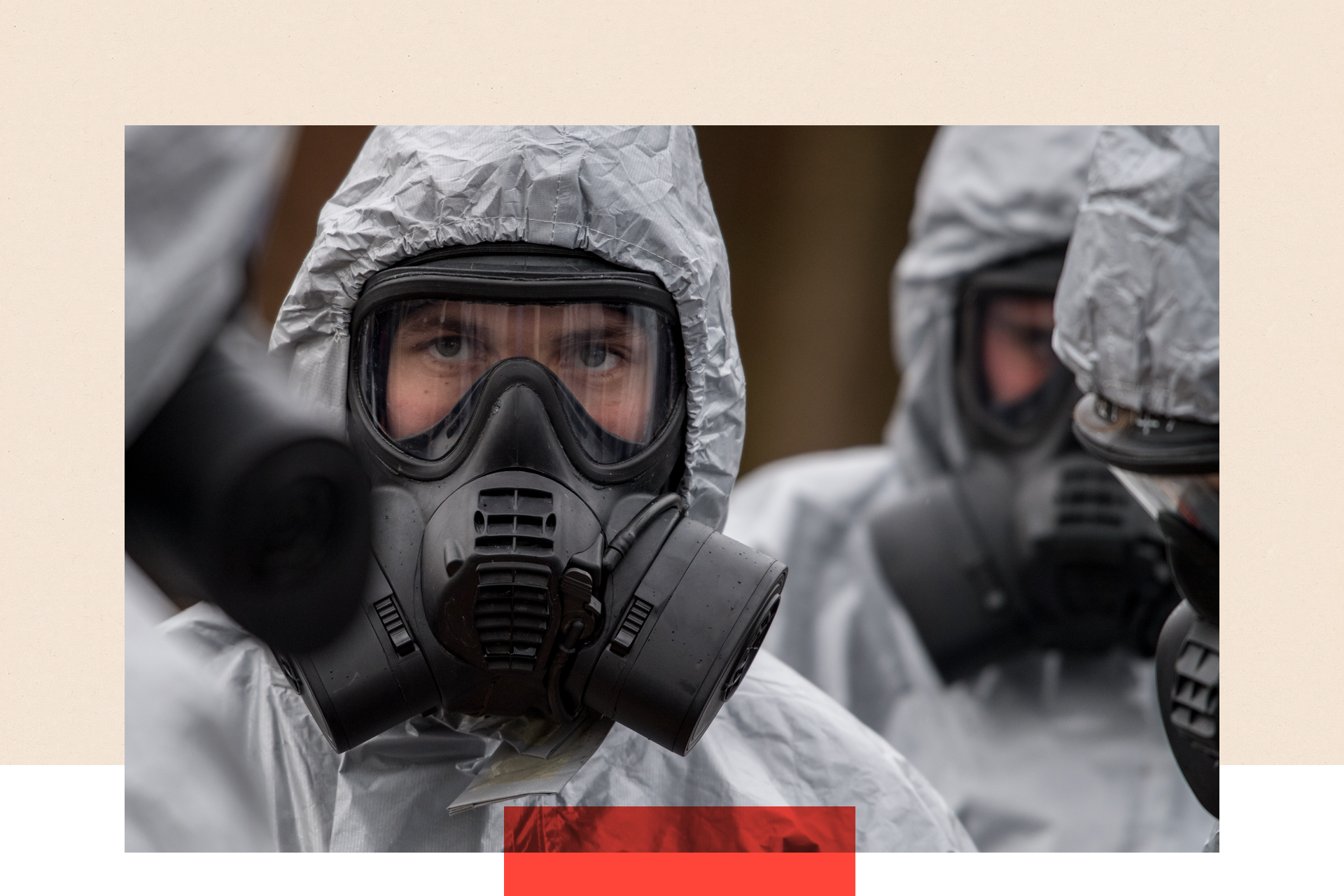 Military personnel wearing protective suits with gas masks