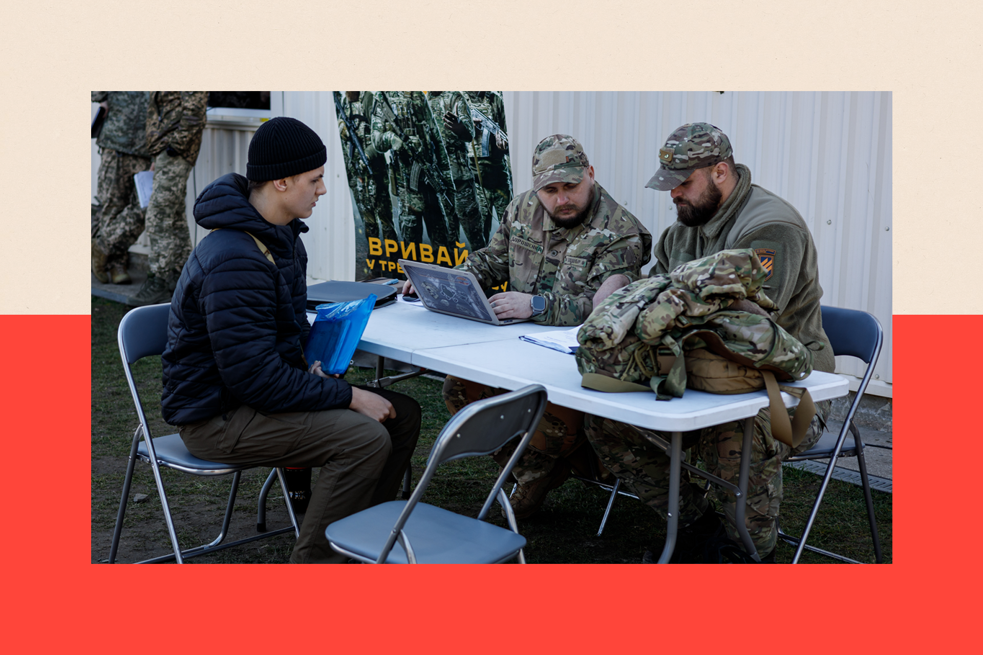 Servicemen talk with a young man at the conscription point 
