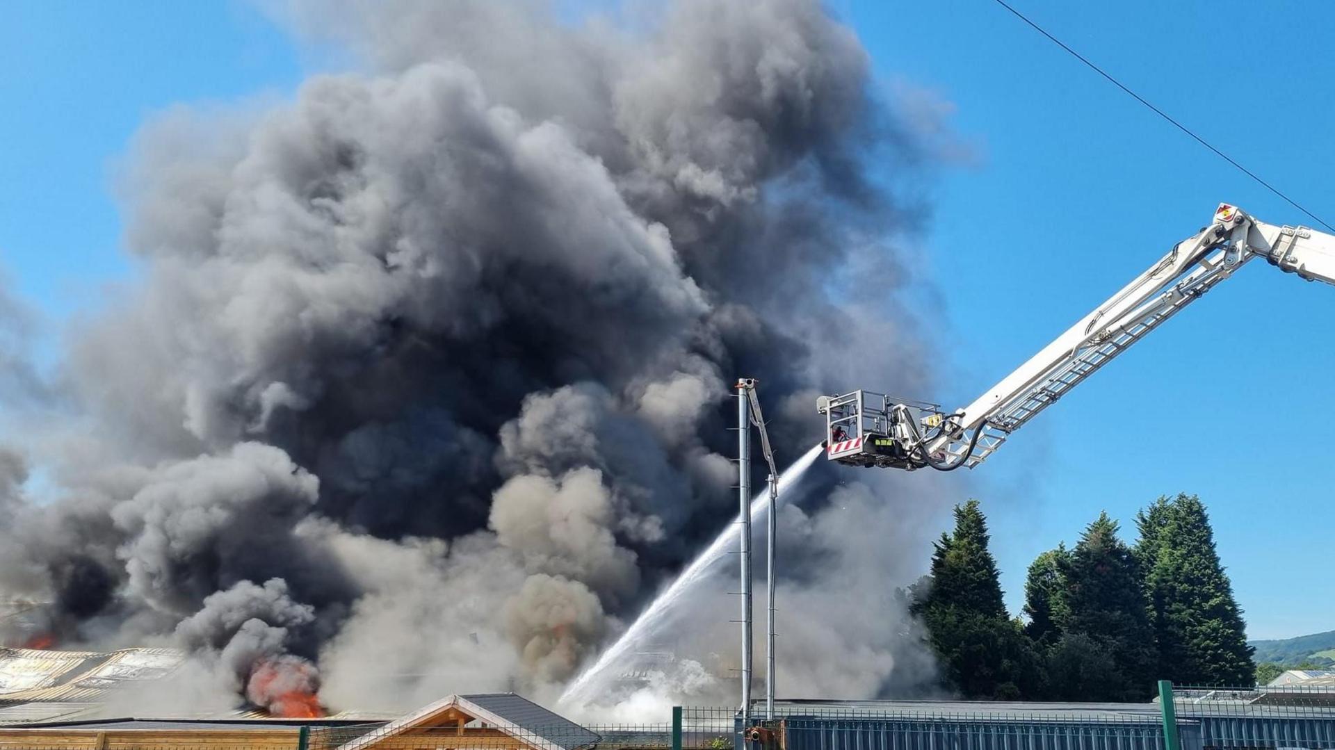 Firefighters battle a garage fire in Heathfield, which is giving off a huge plume of thick grey smoke