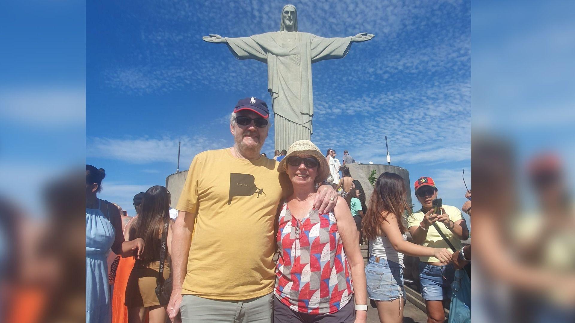 Llun o rieni Guto yn sefyll o flaen Christ the Redeemer ym Mrasil