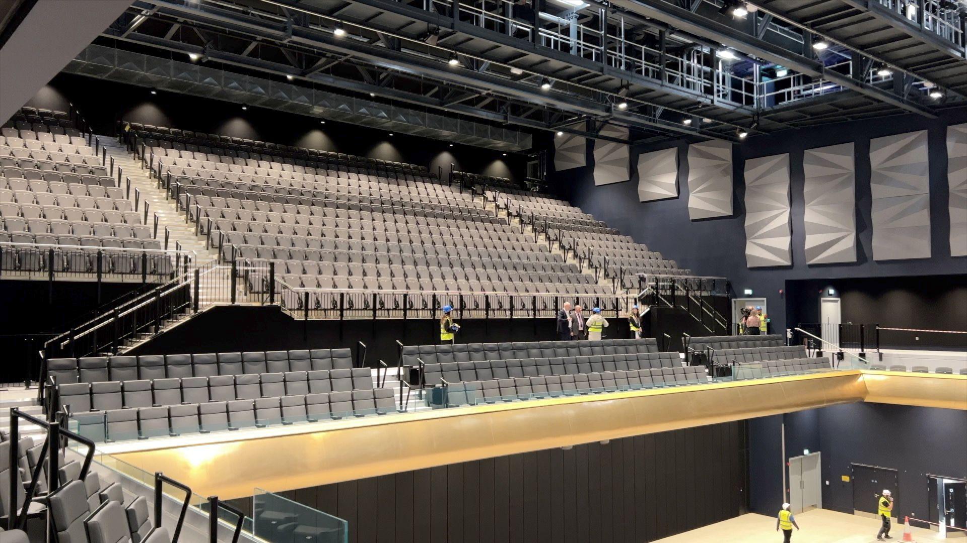 Seating inside the arena - rows of grey seats on a balcony can be seen. 