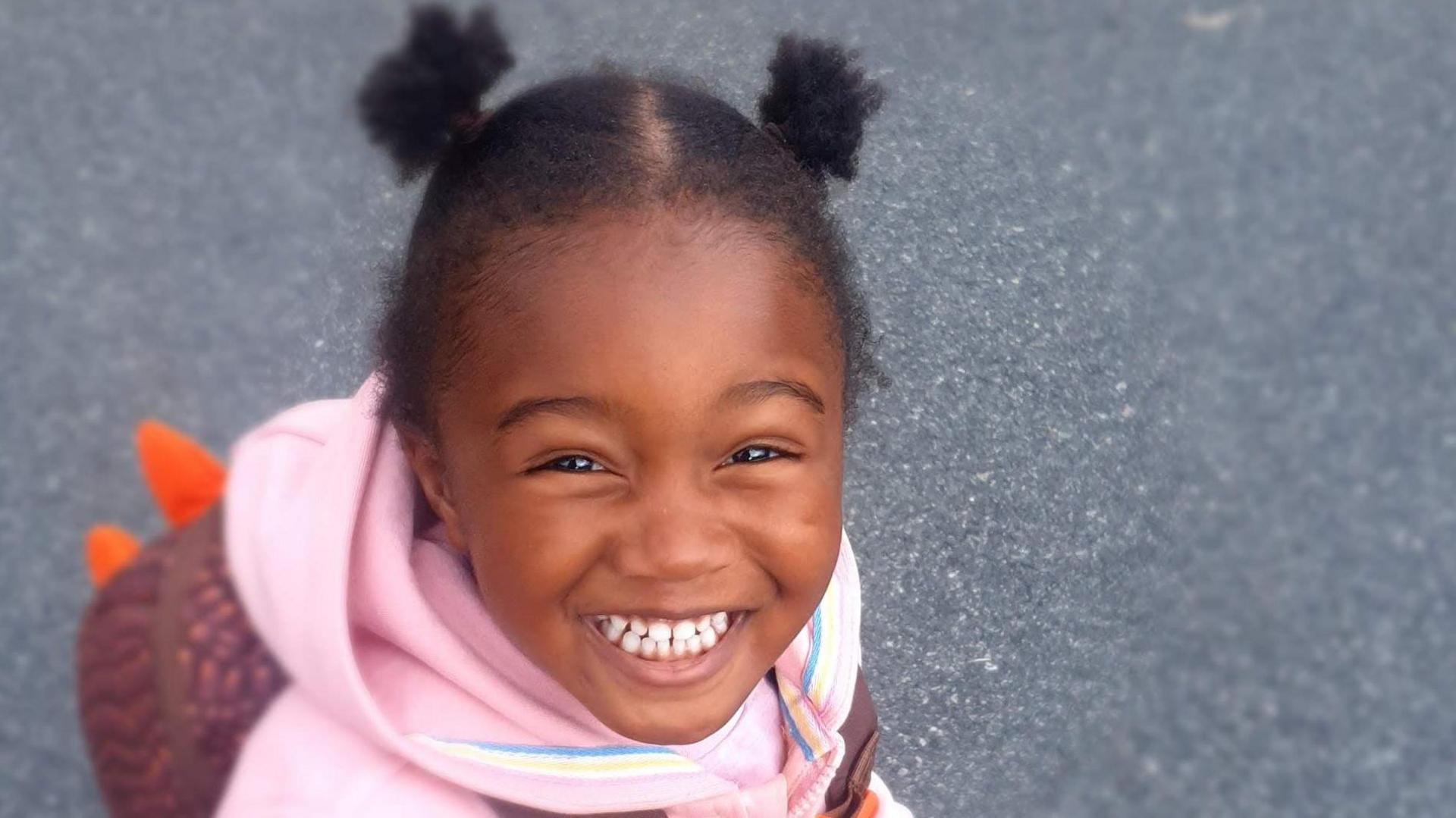 Zadie Ajetunmobi, who is wearing a pink hoodie and smiling at the camera