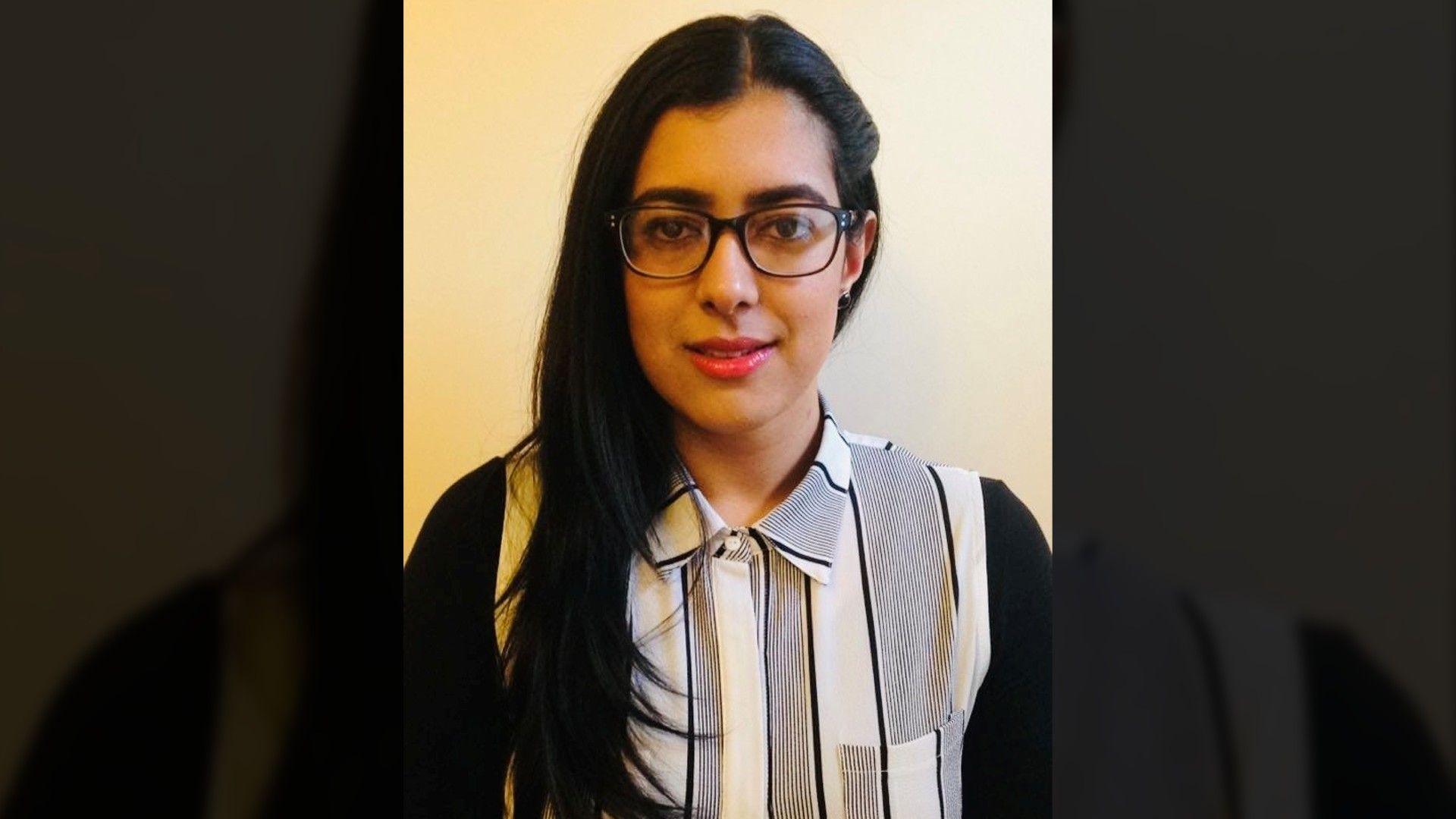 A pistillate   with agelong  acheronian  hairsbreadth  is shown successful  a elemental  representation    against a plain light‑coloured wall. She is wearing glasses and a black‑and‑white striped collared shirt.