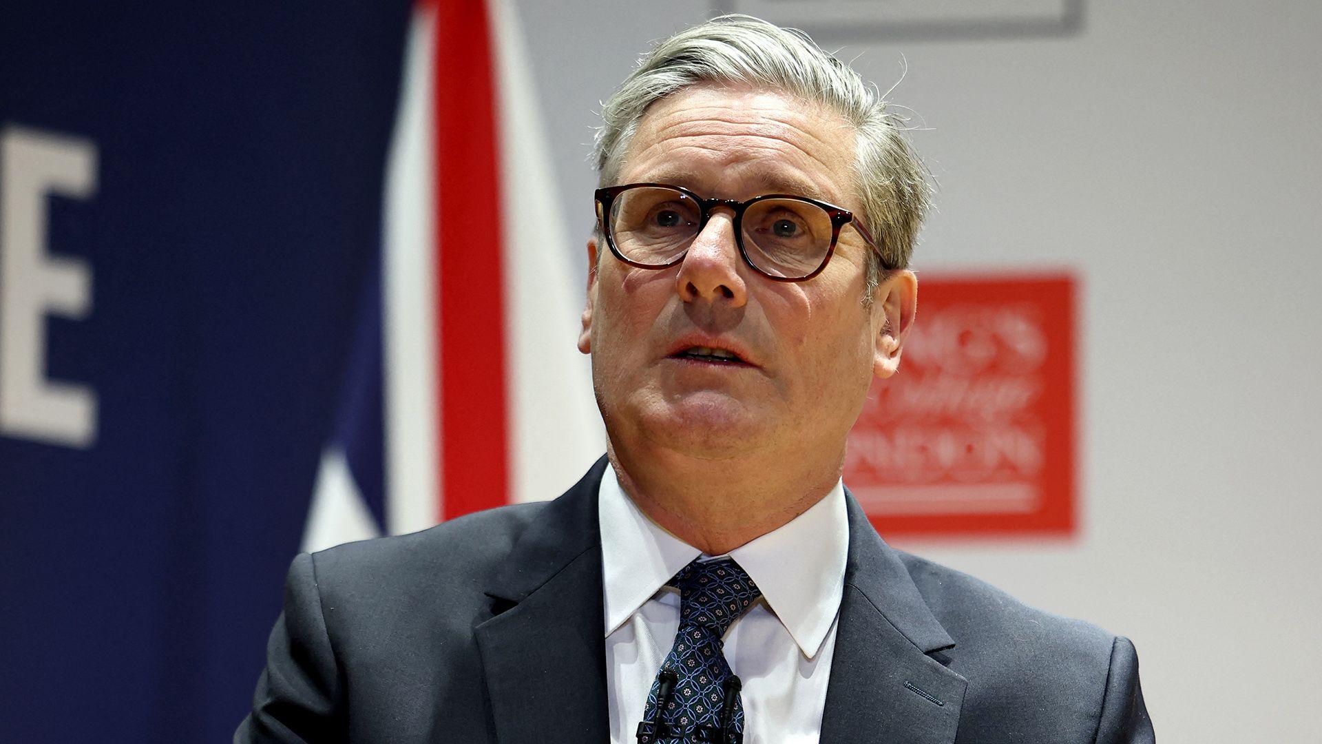 Keir Starmer looks on as he speaks at an event in London on Thursday. He's wearing a suit and tie with glasses on.
