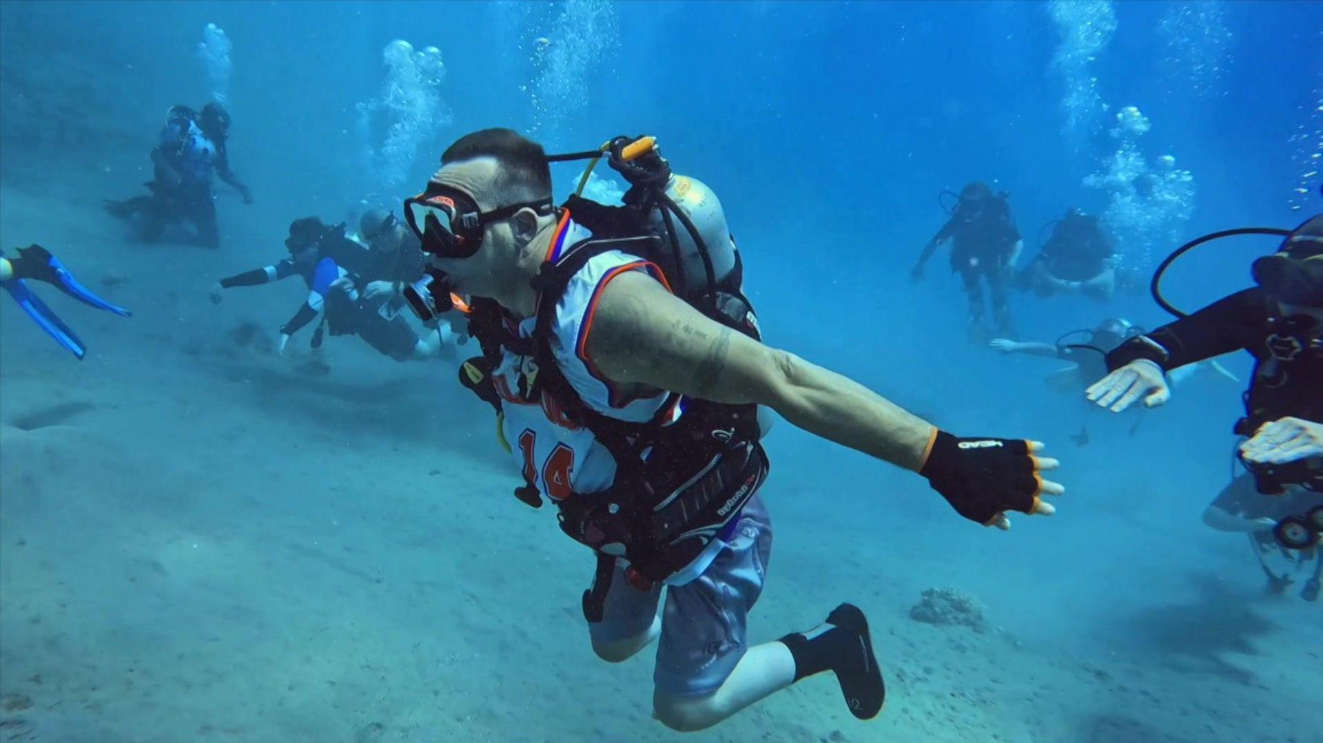 Shaun Gash scuba diving with other divers in the background