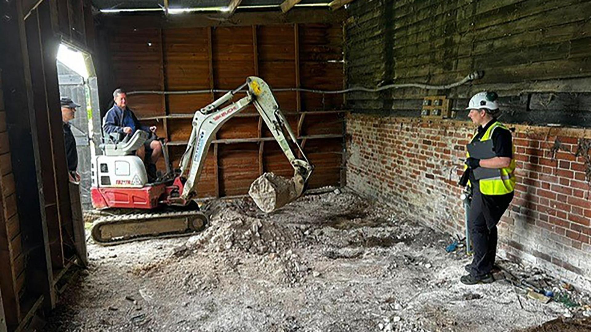 A digger in a farmyard barn