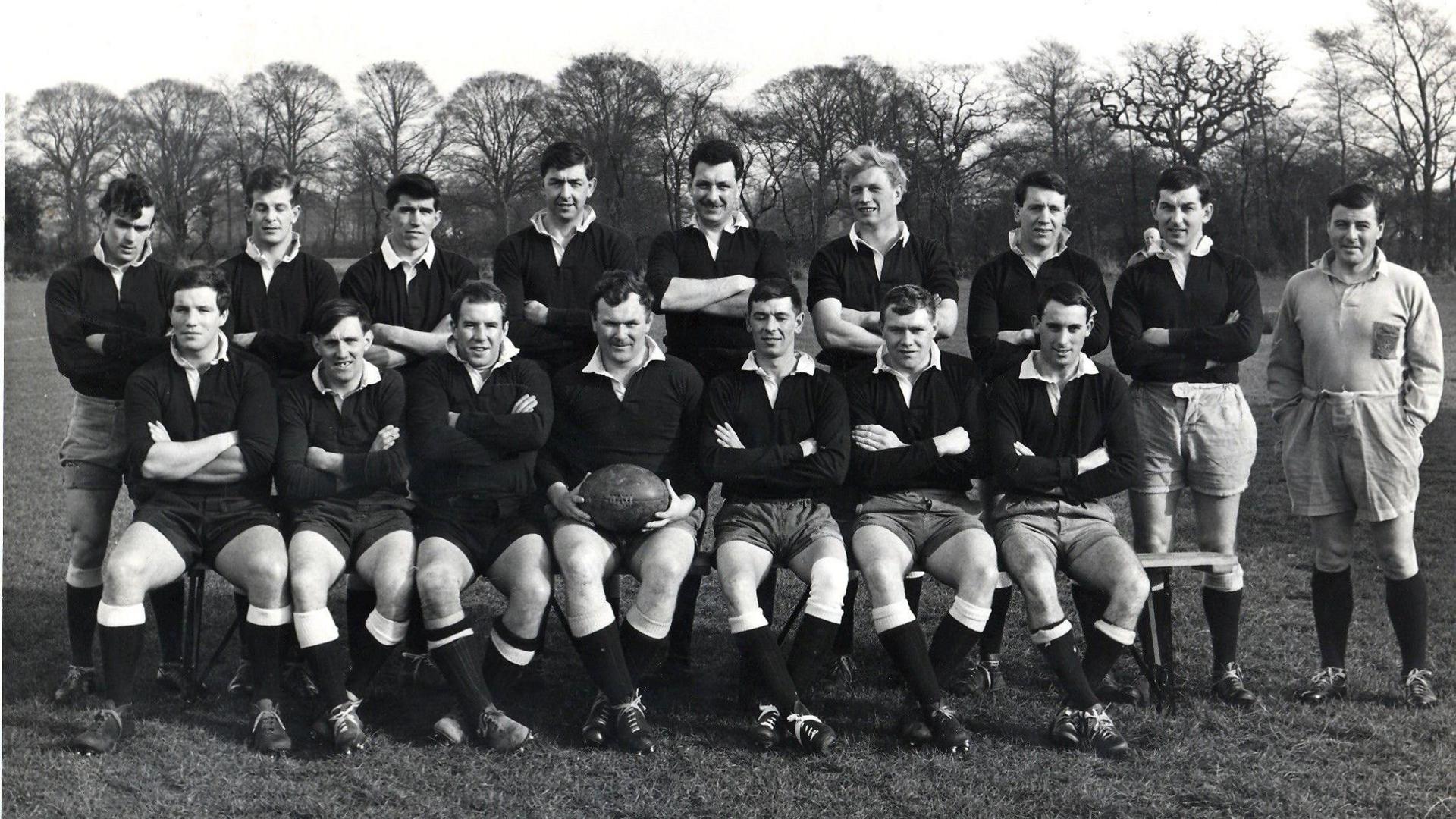 Black and white photo of the Bury Rugby Club players. Some are seated and others are standing behind.