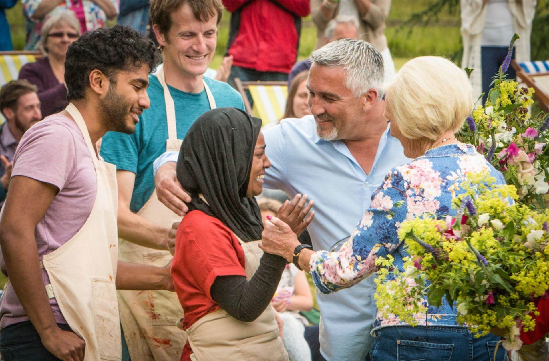 a crying nadiya hussain being comforted by paul hollywood and mary berry after winning bake off