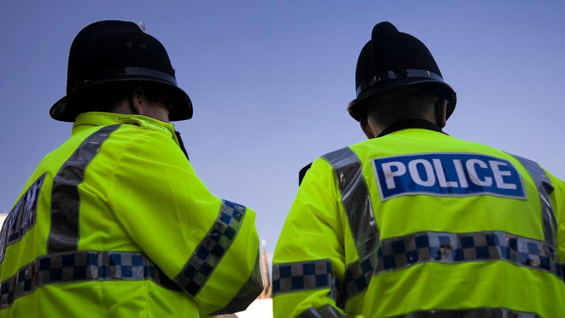 Two police officers in yellow jackets