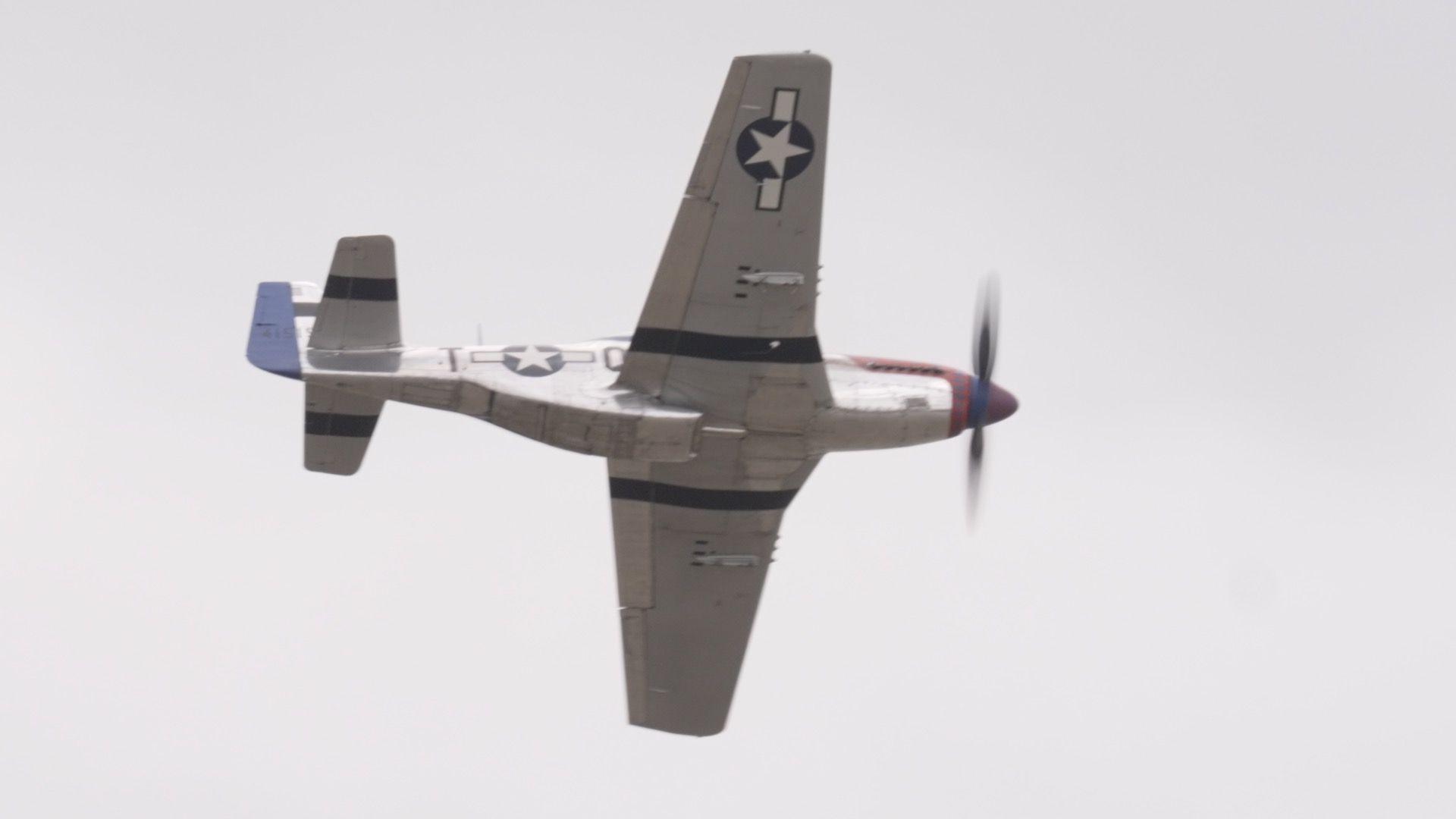 This aeroplane has a propeller attached to its red front. The plane is grey otherwise and has a white star inside a blue circle on its wing and main body.