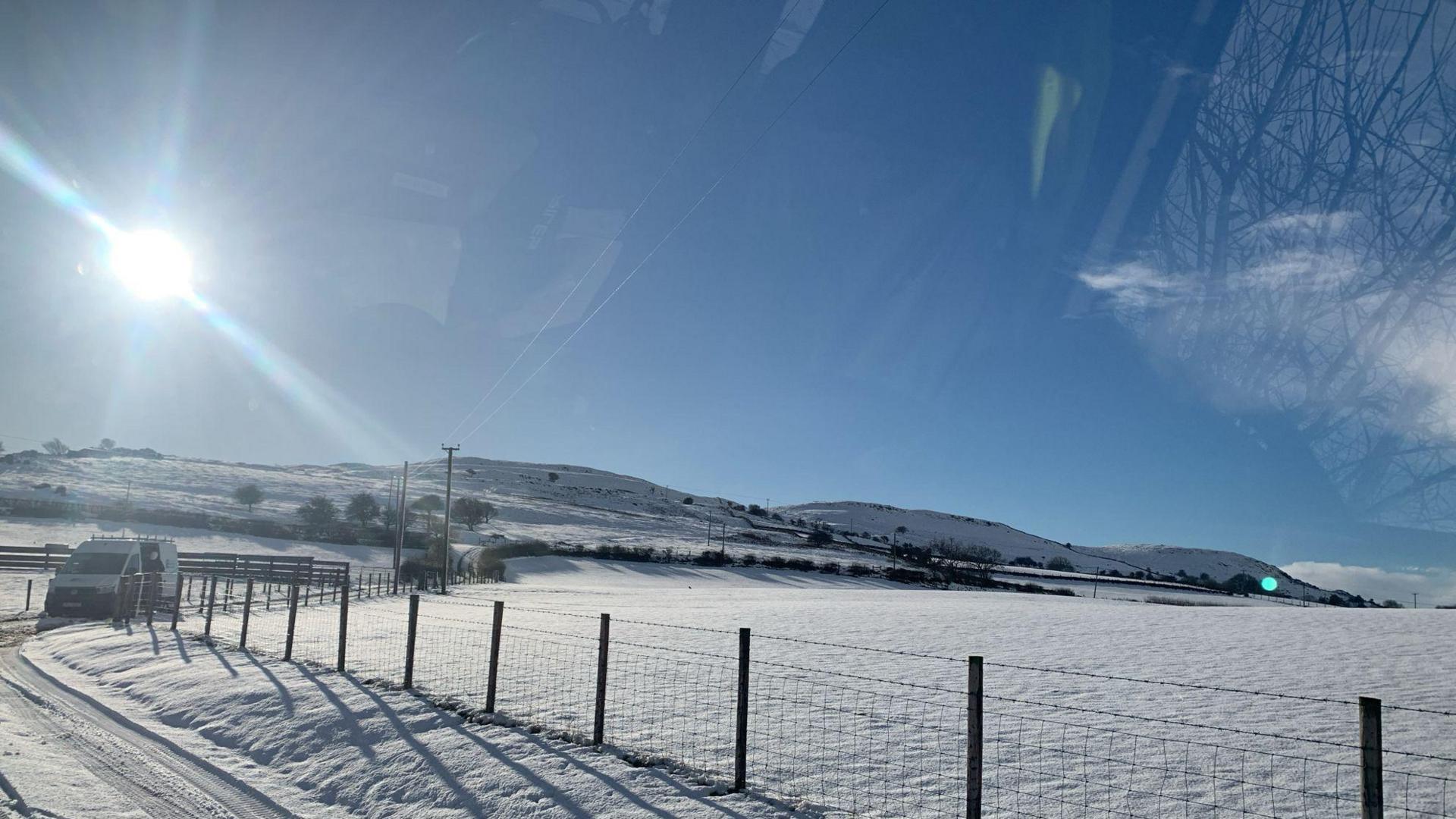 Fields covered in snow, in the background is mountains covered in snow.