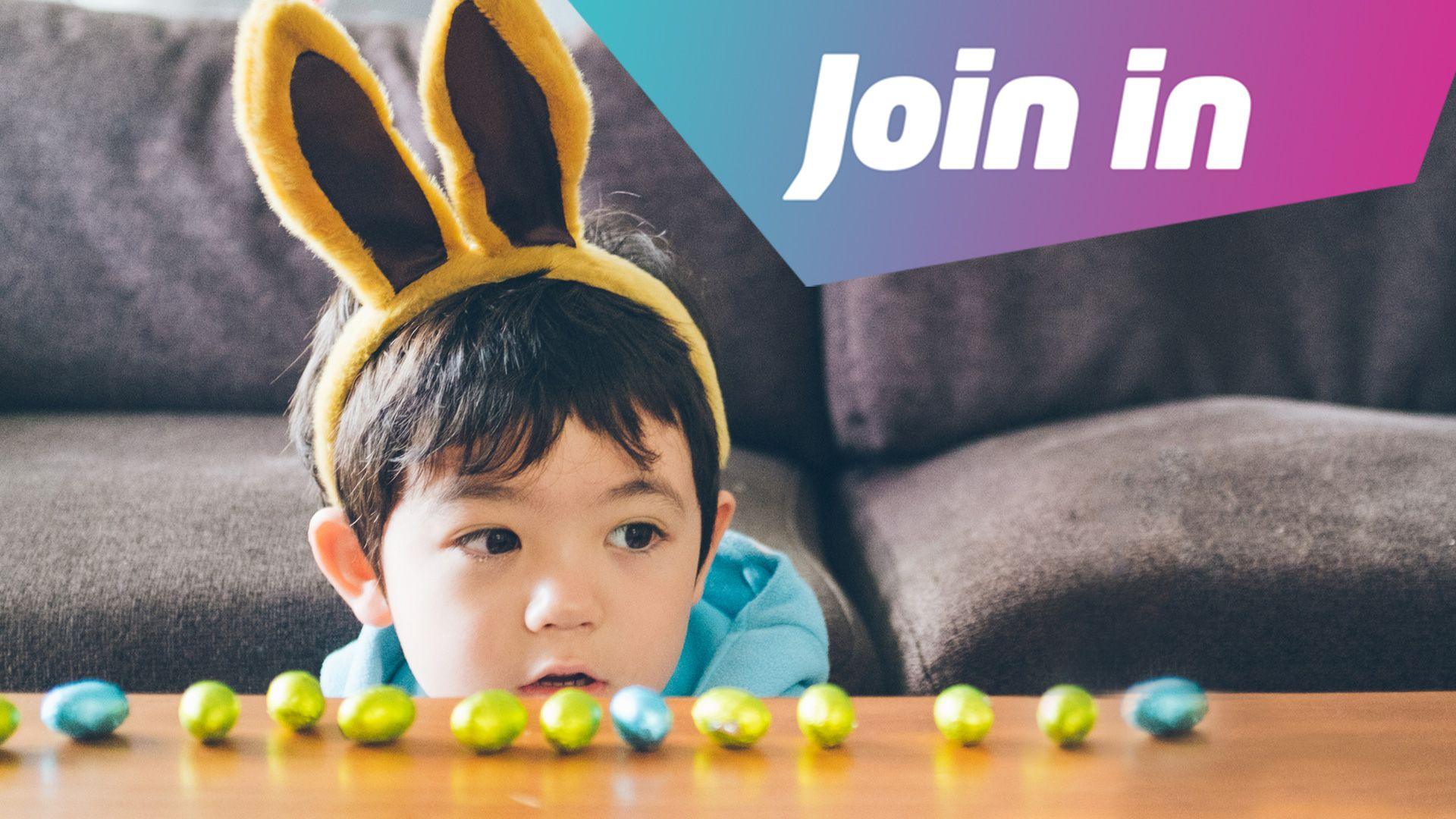 A child wearing easter bunny ears looks at chocolate eggs lined up on the table, with the text Join In in the corner.