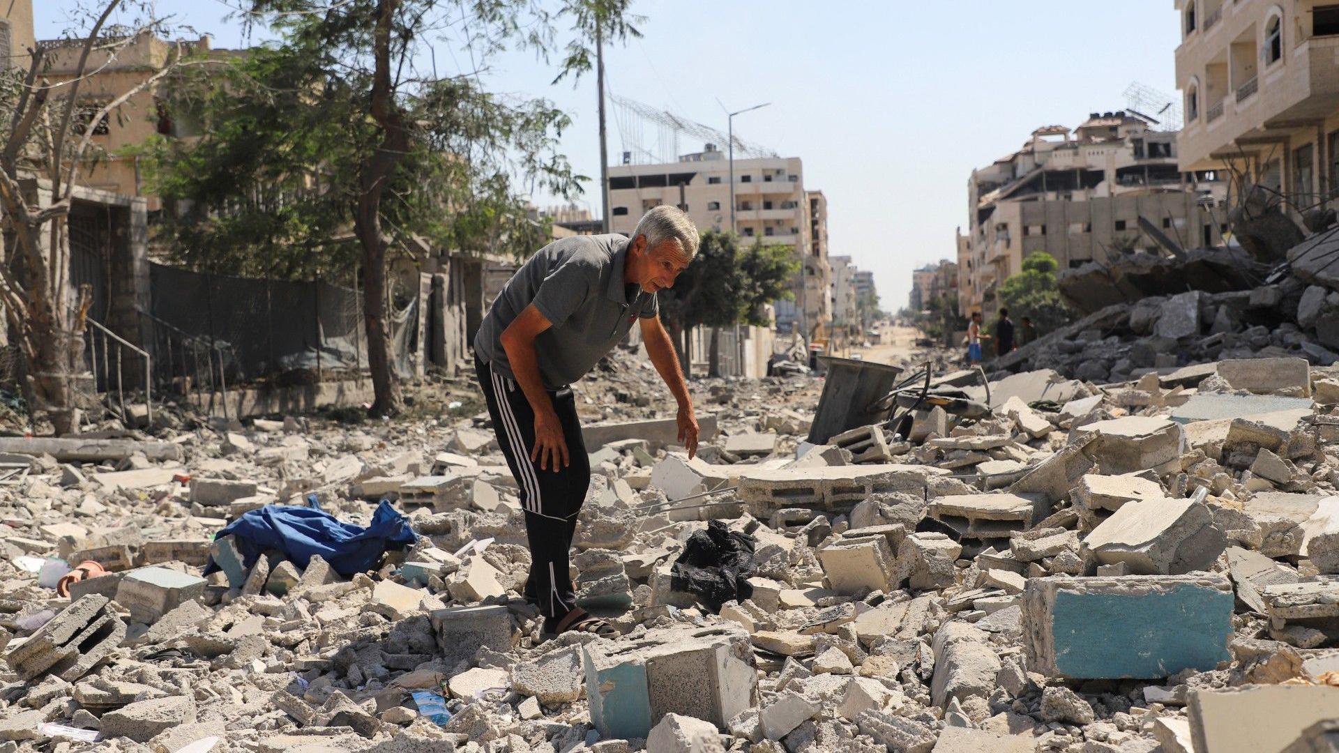 A Palestinian man inspects the damage at a residential neighborhood, following an Israeli operation in the area, after Hamas agreed to release hostages and accept some other terms in a U.S. plan to end the war, in Gaza City, October 4