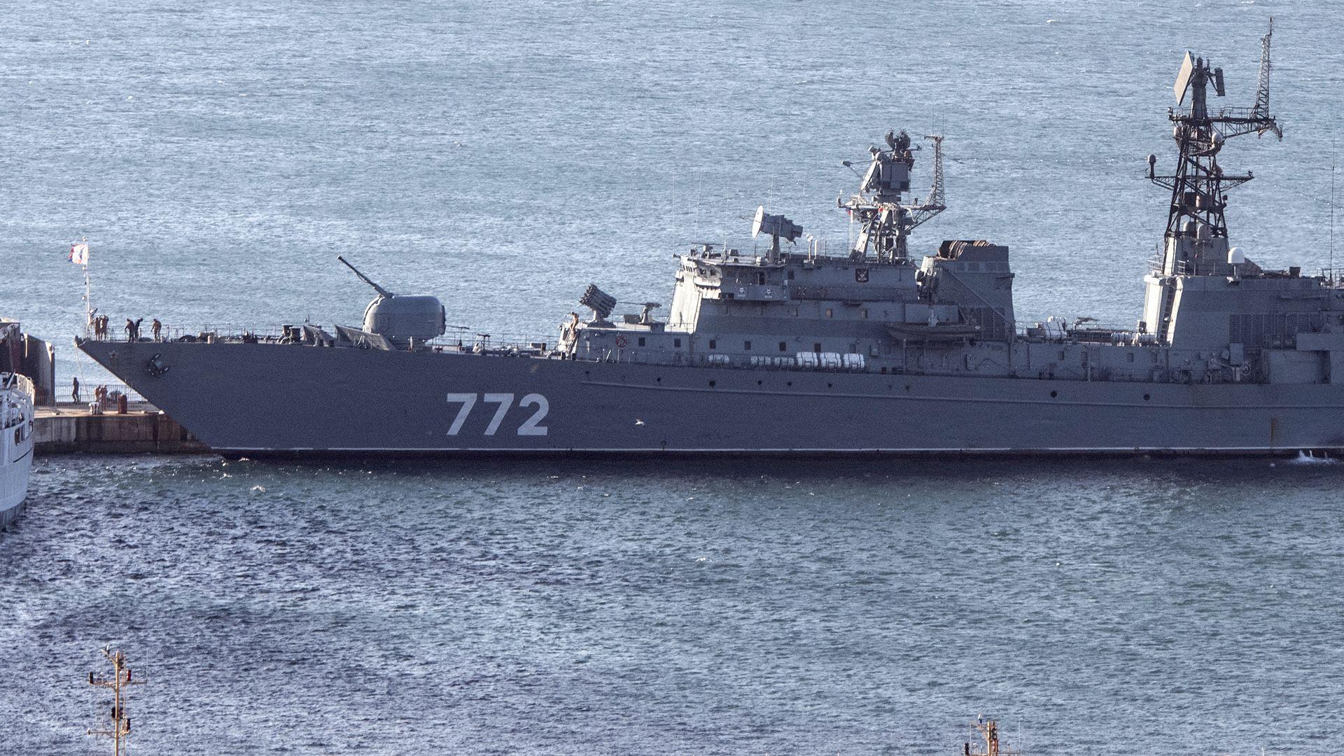 The Russian Neustrashimy frigate - a long, grey vessel with the number 772 printed on the side in white - in the water.
