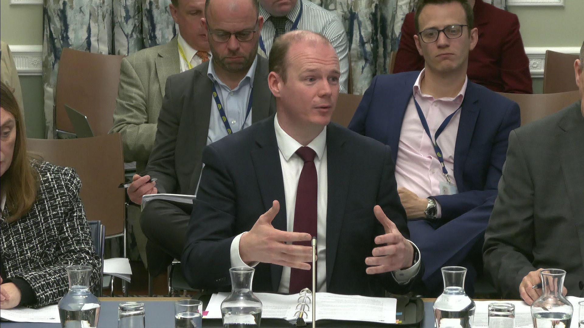 Communities Minister Gordon Lyons speaking at a Stormont committee