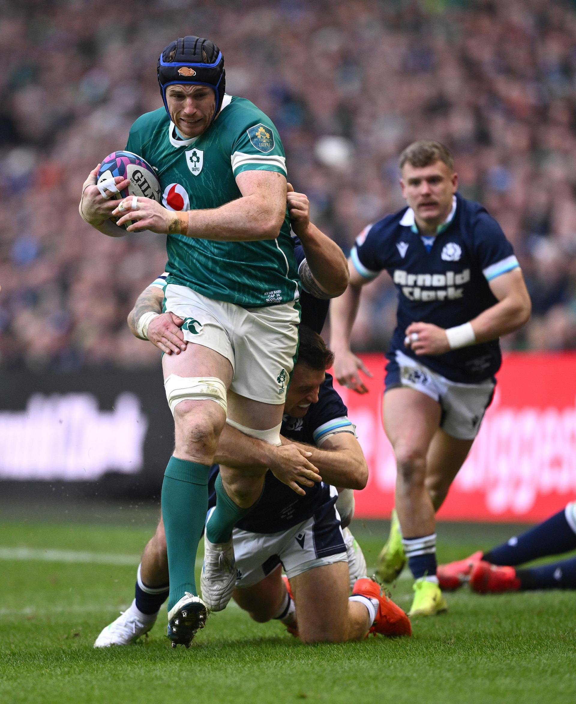 Ryan Baird of Ireland is tackled by Rory Sutherland and Ben White of Scotland during the Guinness Six Nations 2025 match between Scotland and Ireland at Scottish Gas Murrayfield in Edinburgh, Scotland