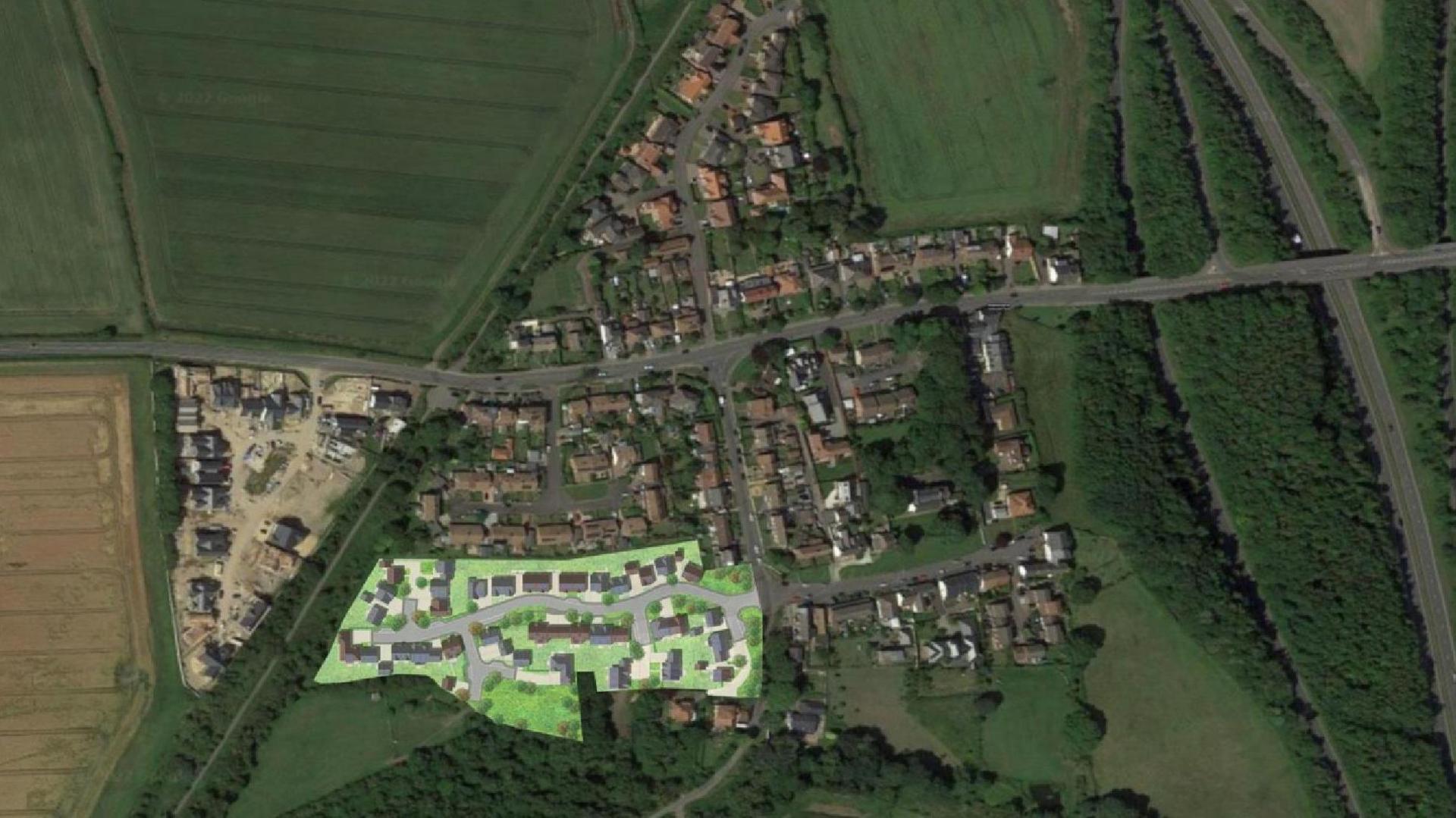 Aerial artist's impression showing where the proposed homes would sit in relation to existing properties. The village is surrounded by fields with some roads cutting through.