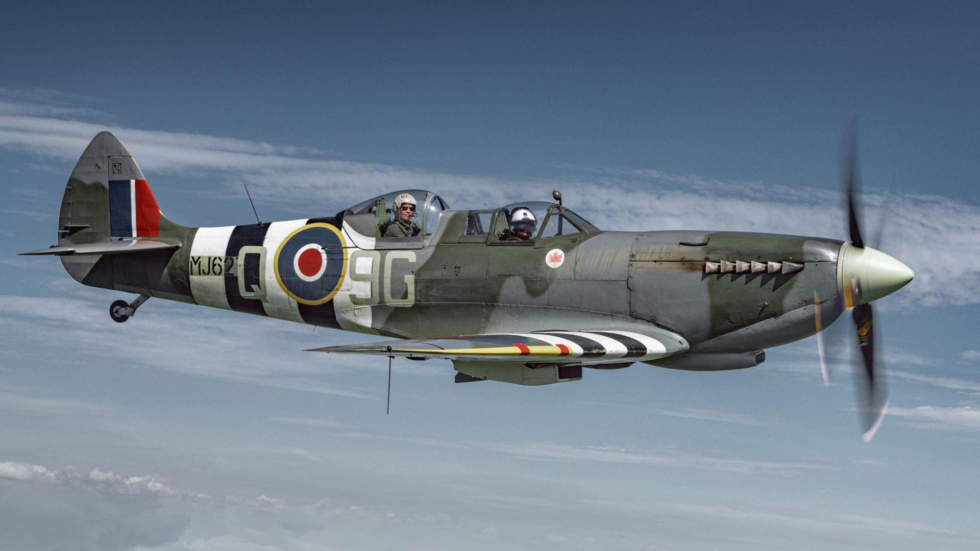 Side view of a Spitfire in the sky with the Royal Airforce emblem on the side.