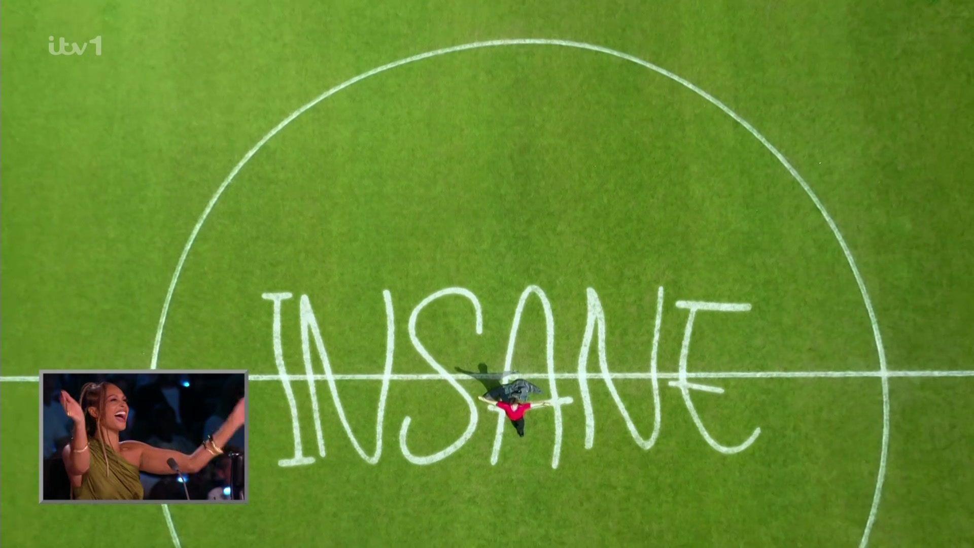 aerial shot of a football pitch with the word "insane" written on it. Alesha Dixon is seen laughing and cheering