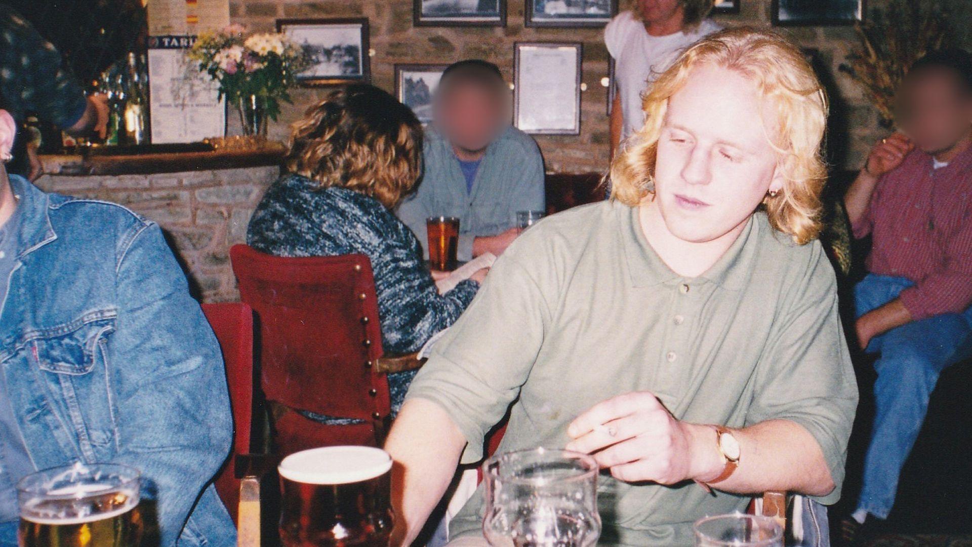 Rob Russell at a pub table, with pint of beer on the table in front of him