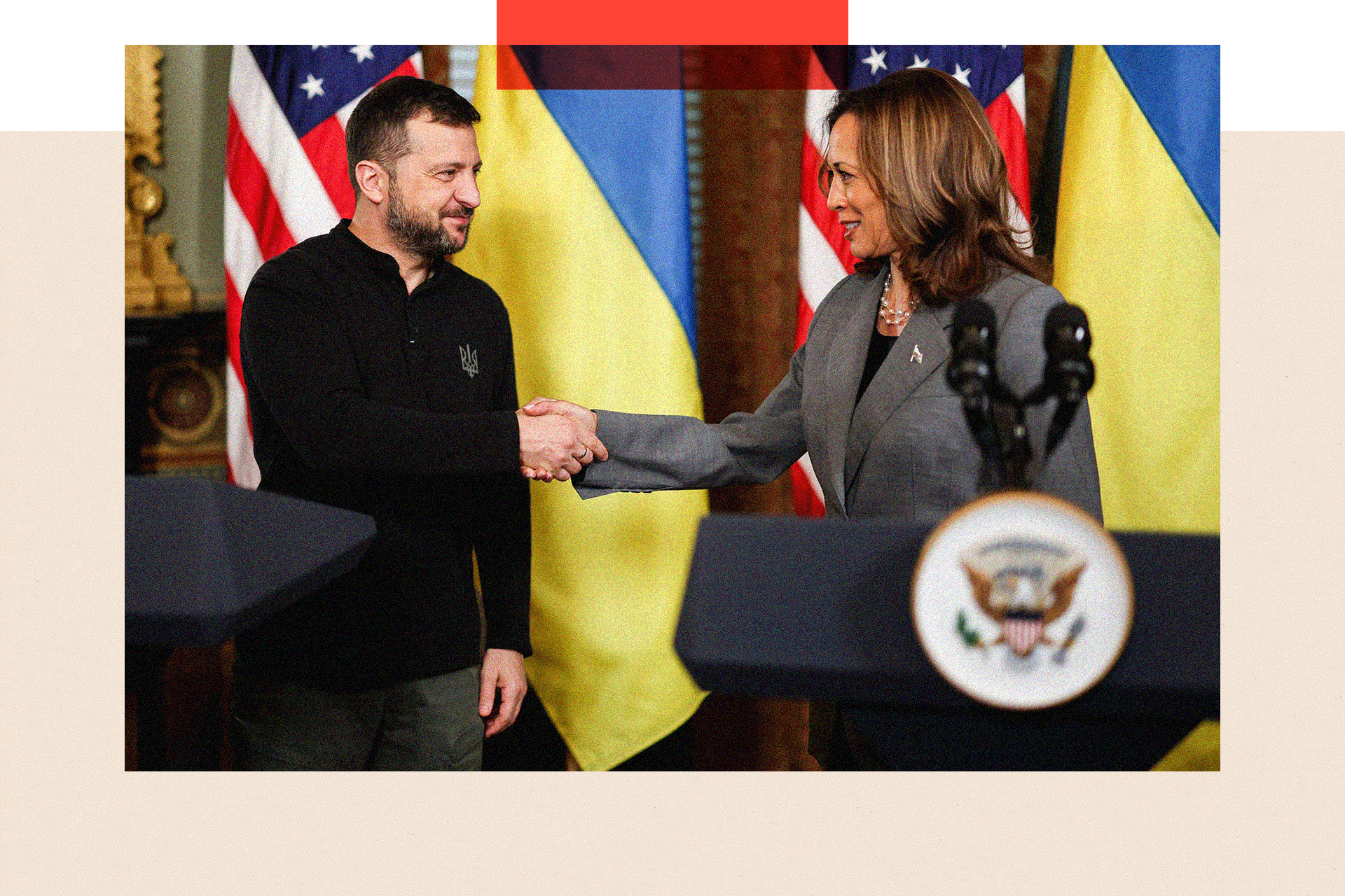 Volodymyr Zelensky and Kamala Harris shake hands on a stage in front of the Ukrainian flag and the US flag