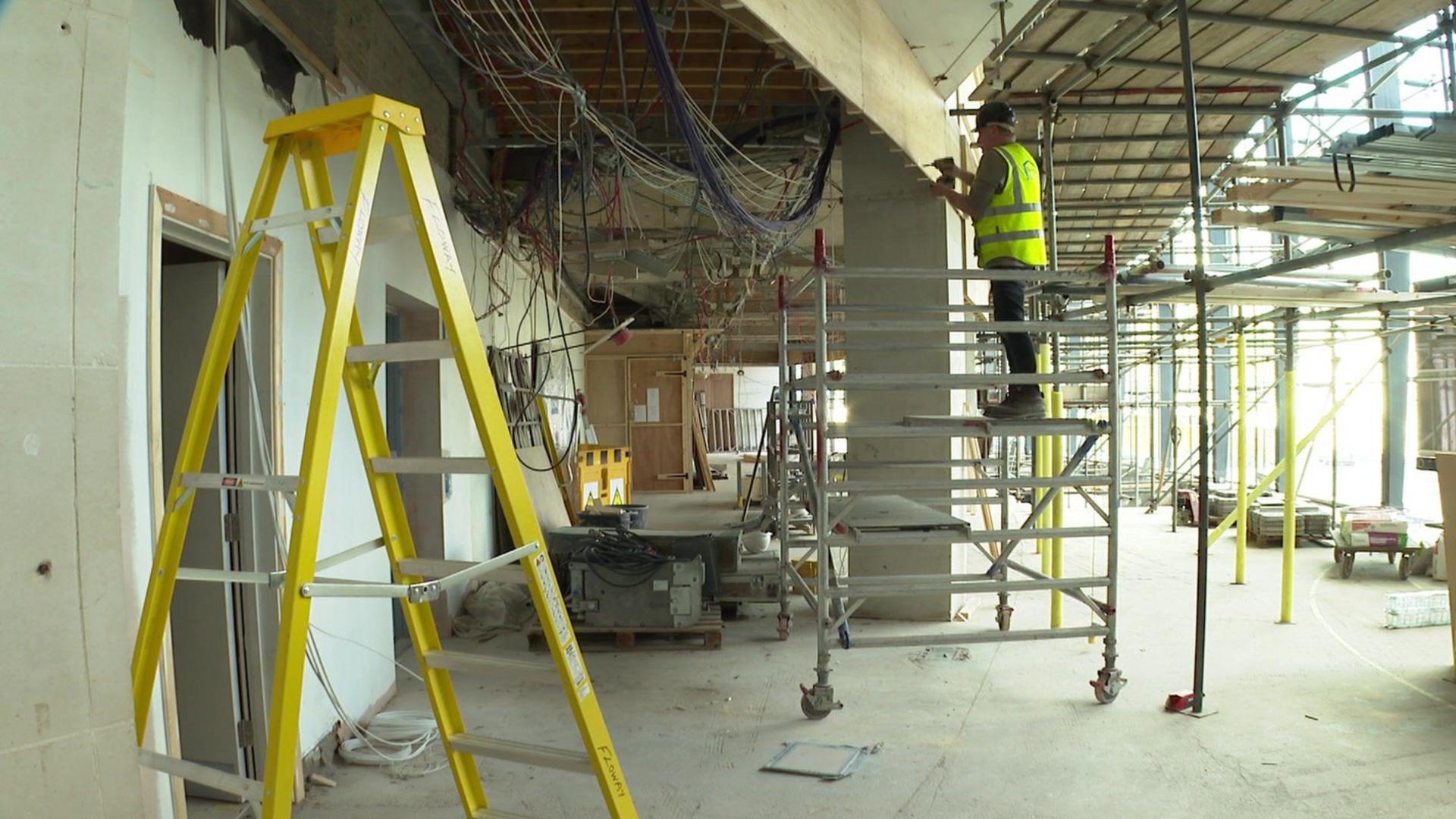 A builder standing on scaffolding in the National Science and Media Museum while it is being refurbished